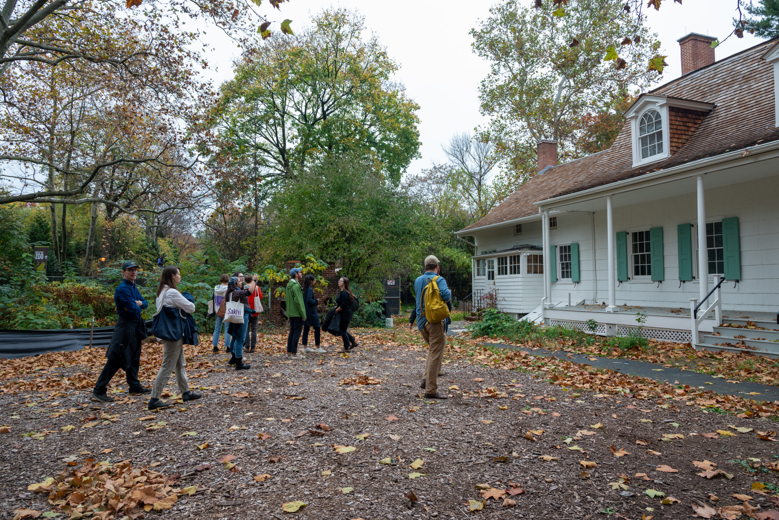 一群学生走近树木繁茂的白色殖民时期的房子