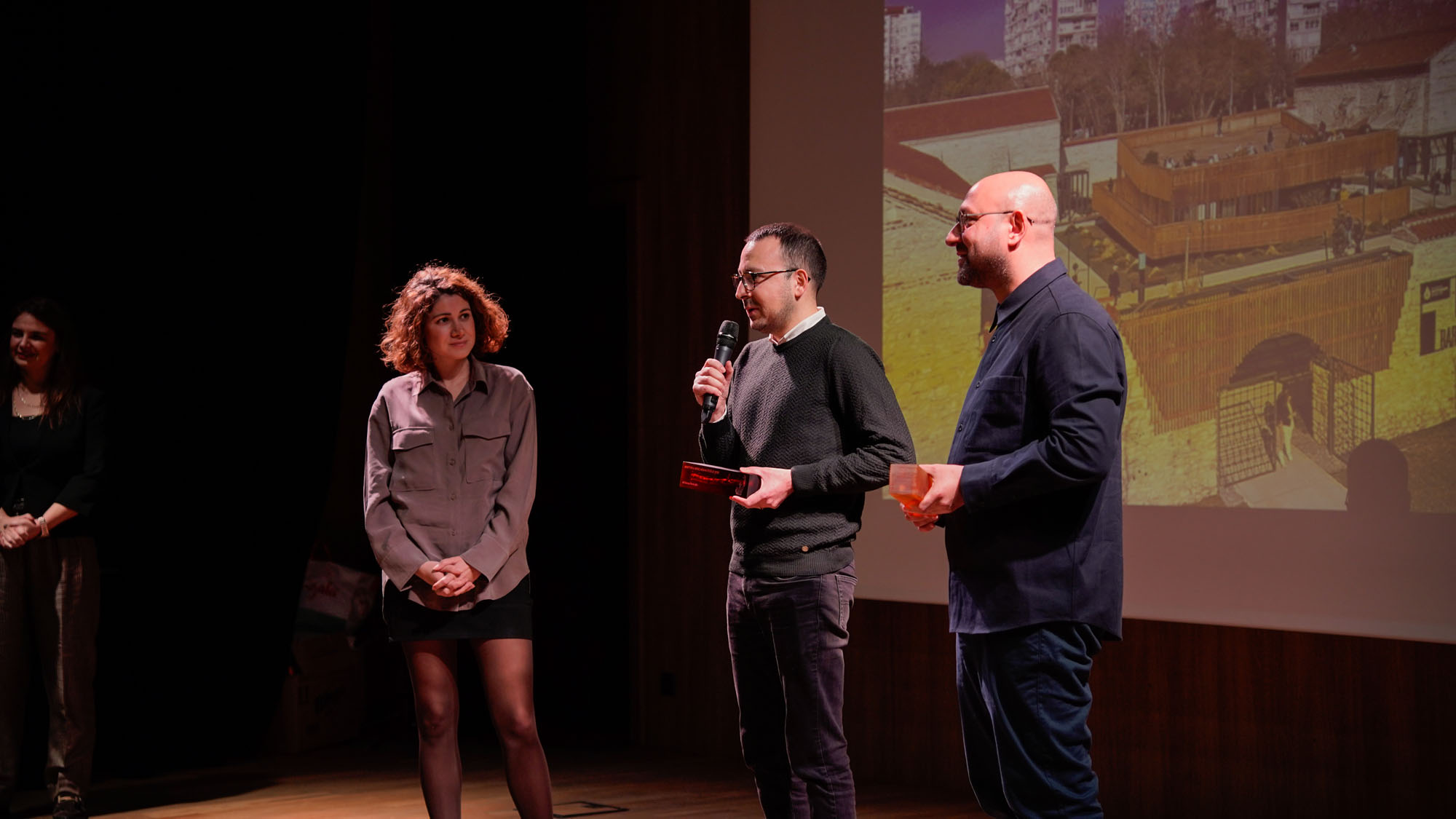 Ali Derya Dostoğlu ’11 on stage receiving the 2025 Arkitera Young Architect Award 2025