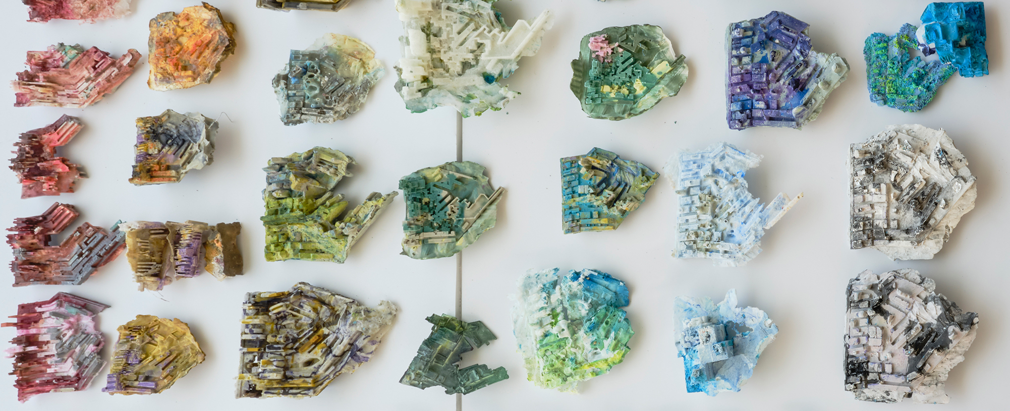 Image of a collection of multicolored topographic models created using plaster.