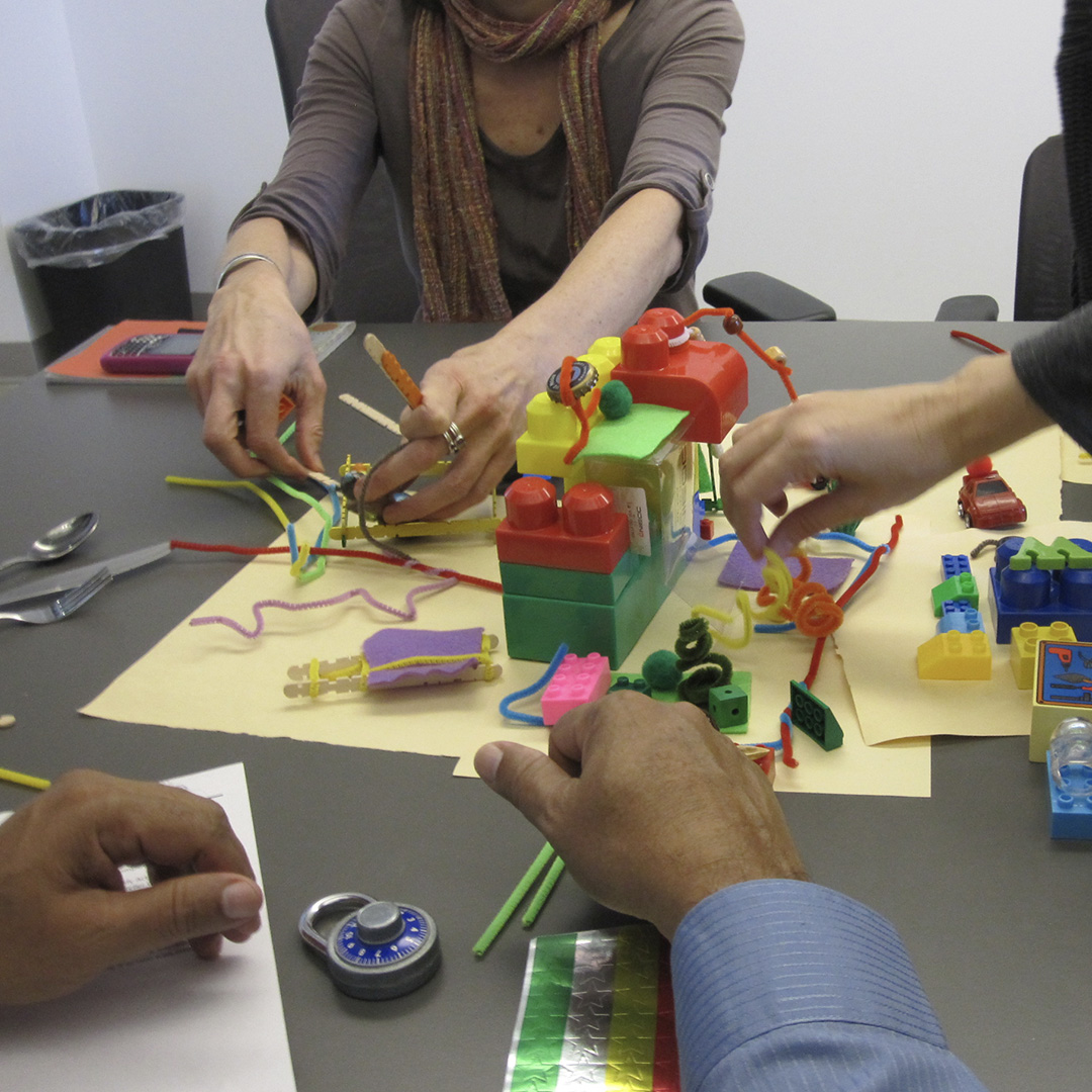 people using building blocks, at a table, two sets of hands working
