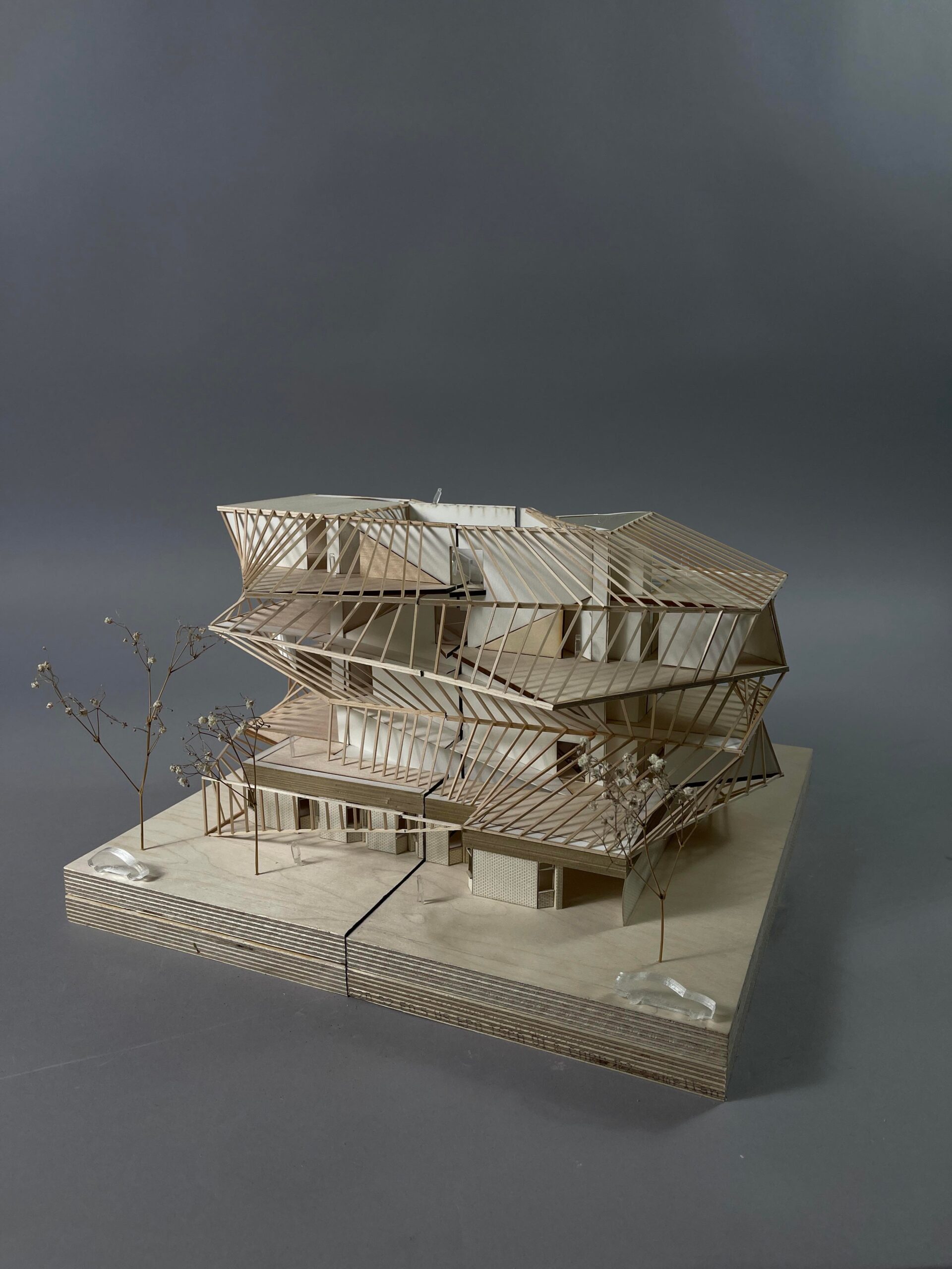 A 3D model of a multi-leveled structure with terraces framed by angled beams. The model is made of wood.