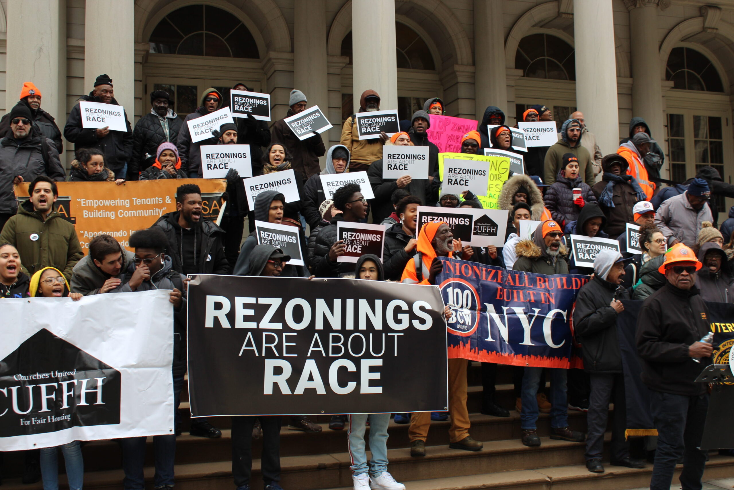 People protesting for housing justice outside of a courthouse.