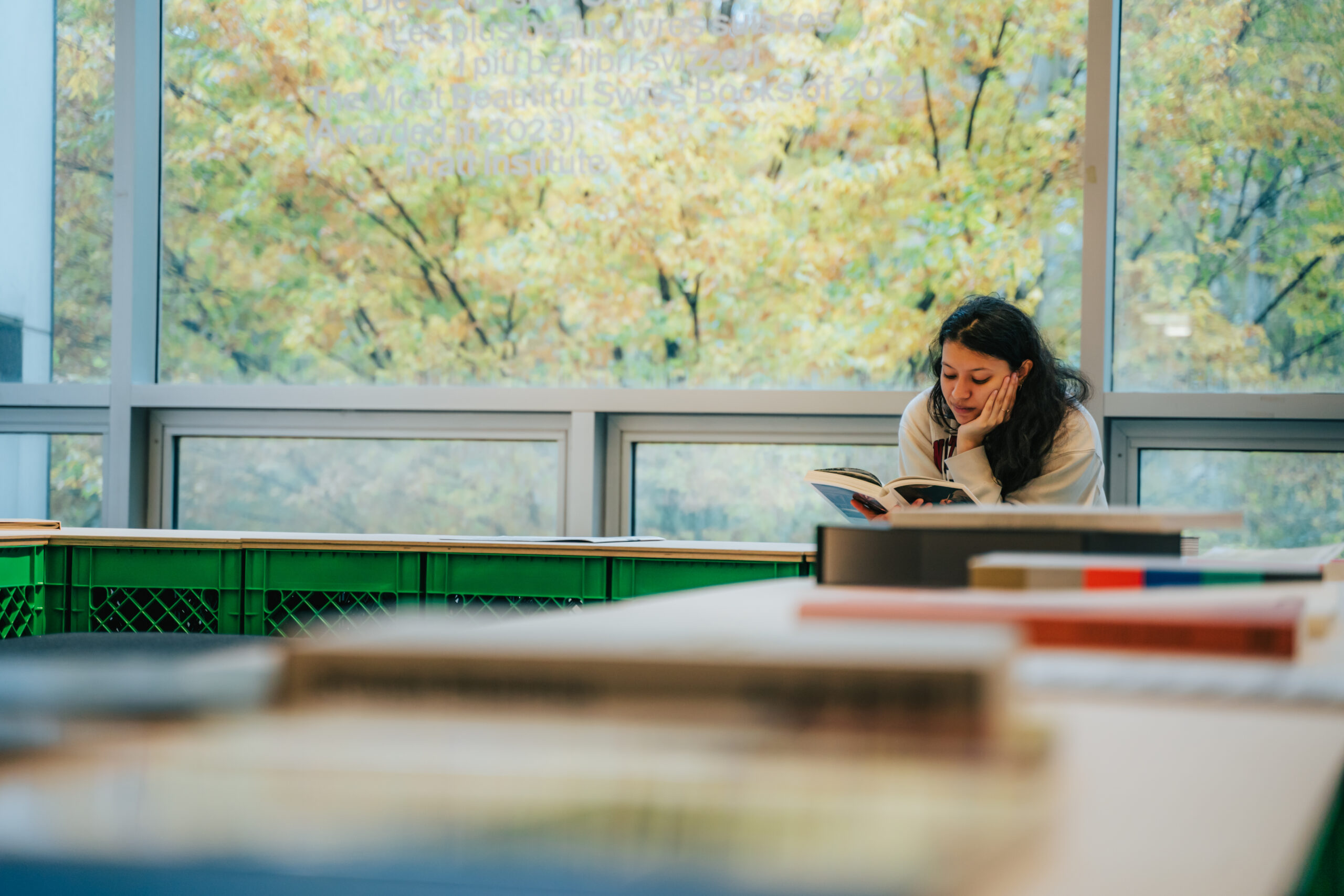 Student seated at table reading book