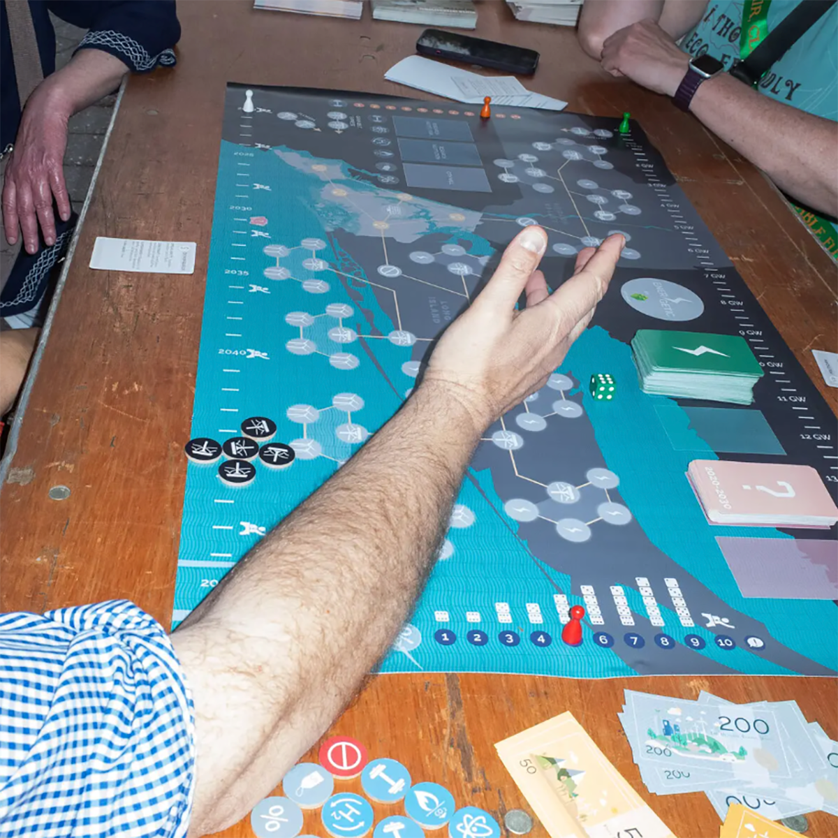 A board game with red and green markers, energy credits, and tokens.