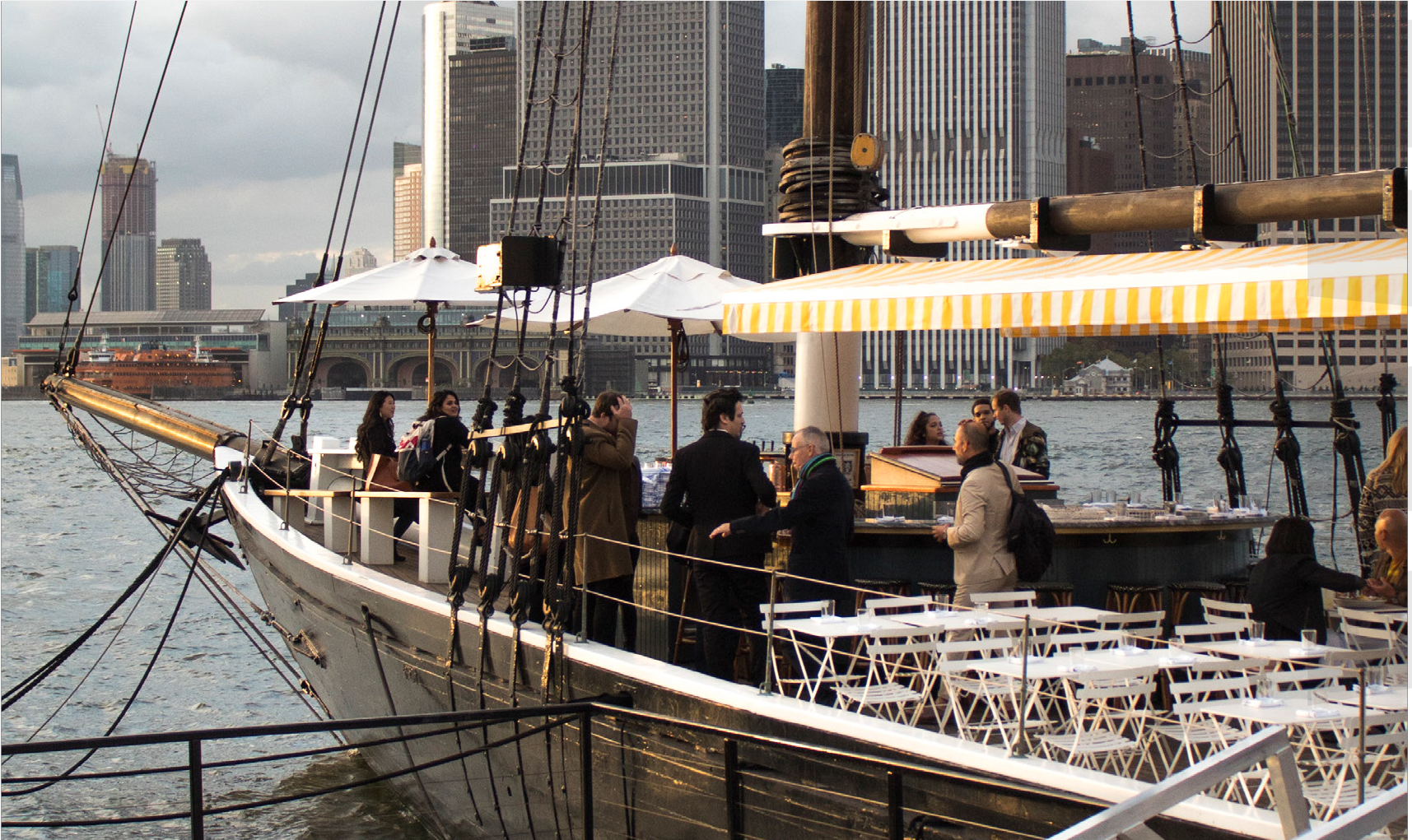 People on a boat with New York City in the background.