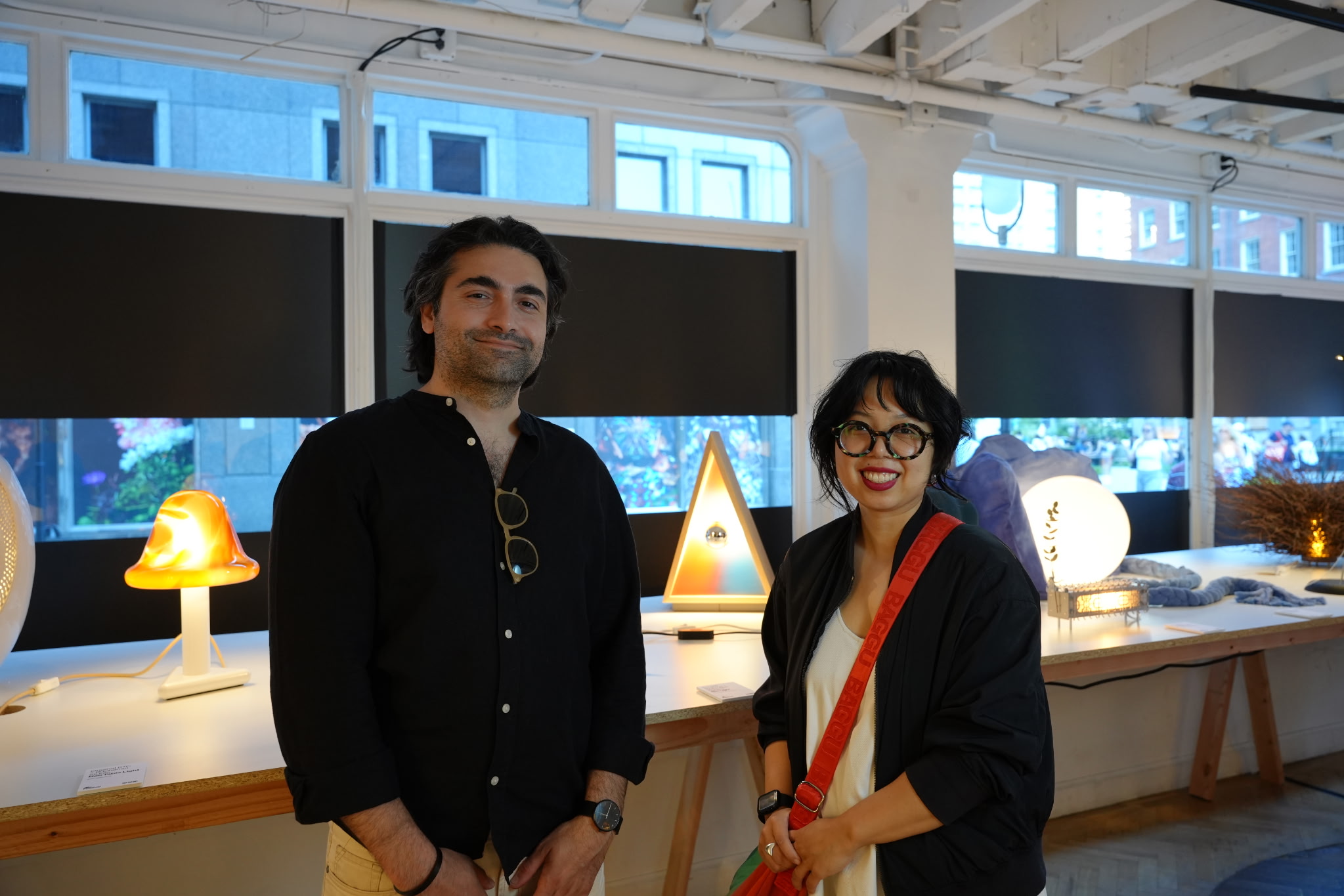 Man and woman in front of tabletop light fixtures.