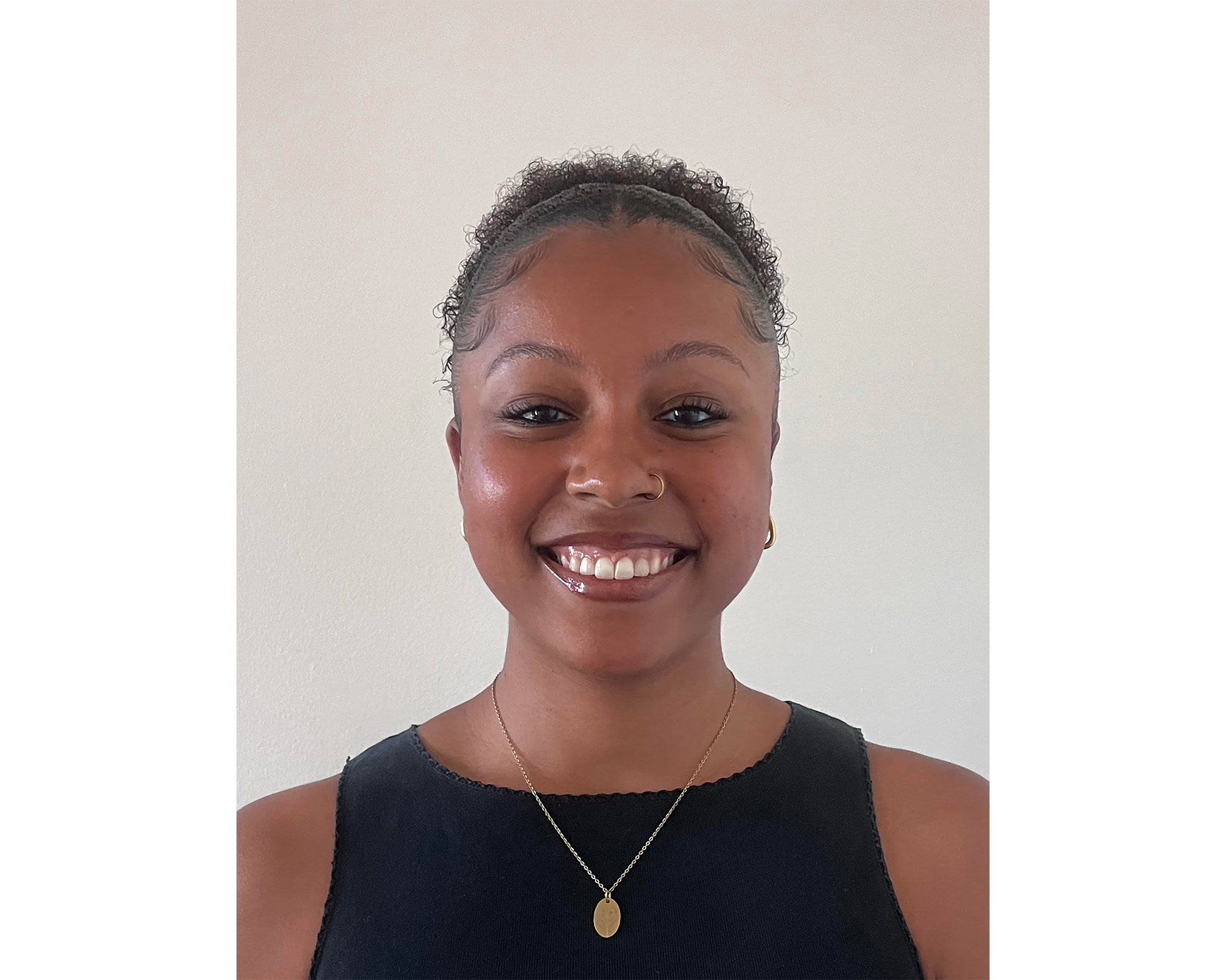 Headshot of Kayla Sparks smiling warmly against a neutral background.