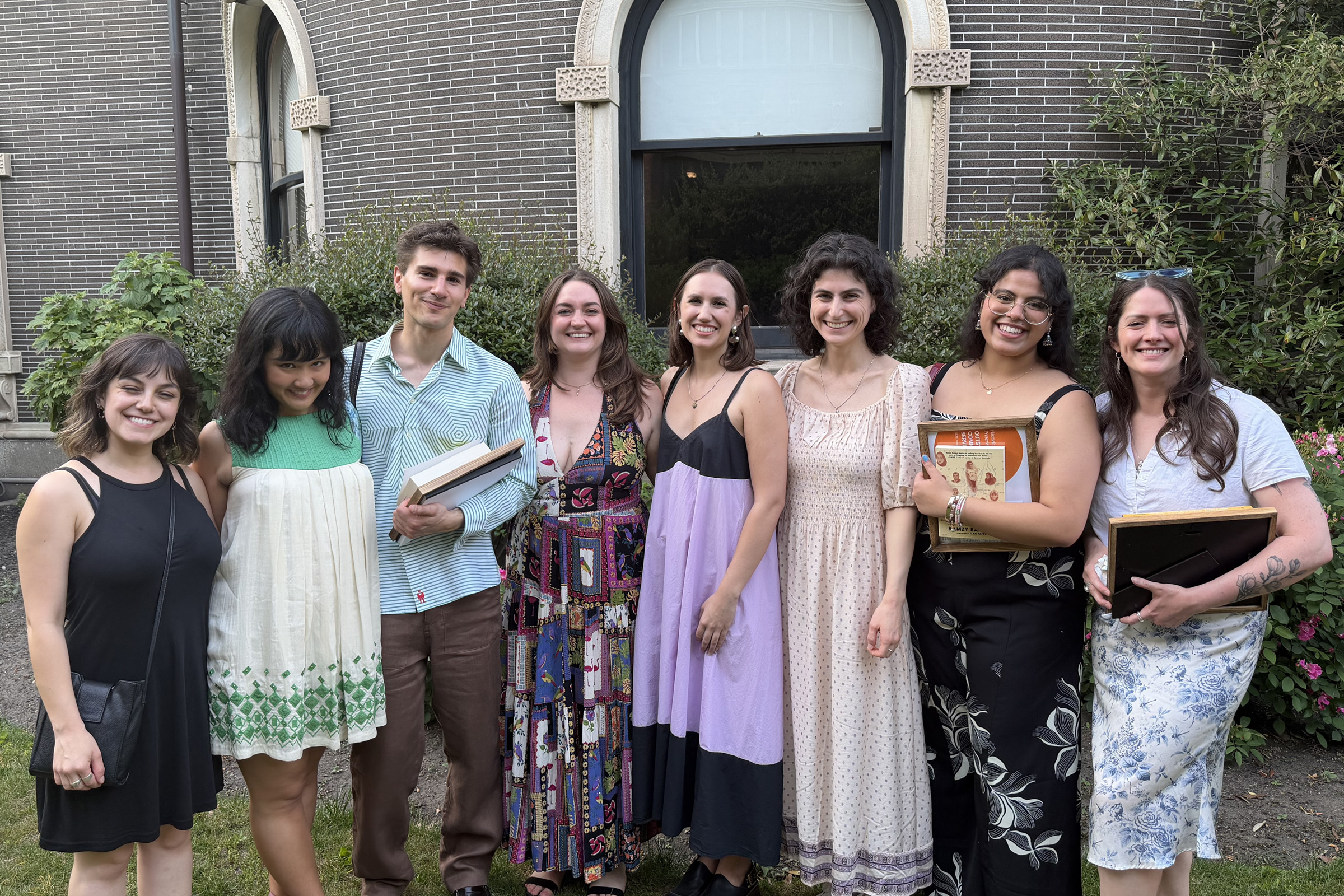 HPCohort_GCPE_GradParty.jpg — A group of eight students standing outside a brick manor.