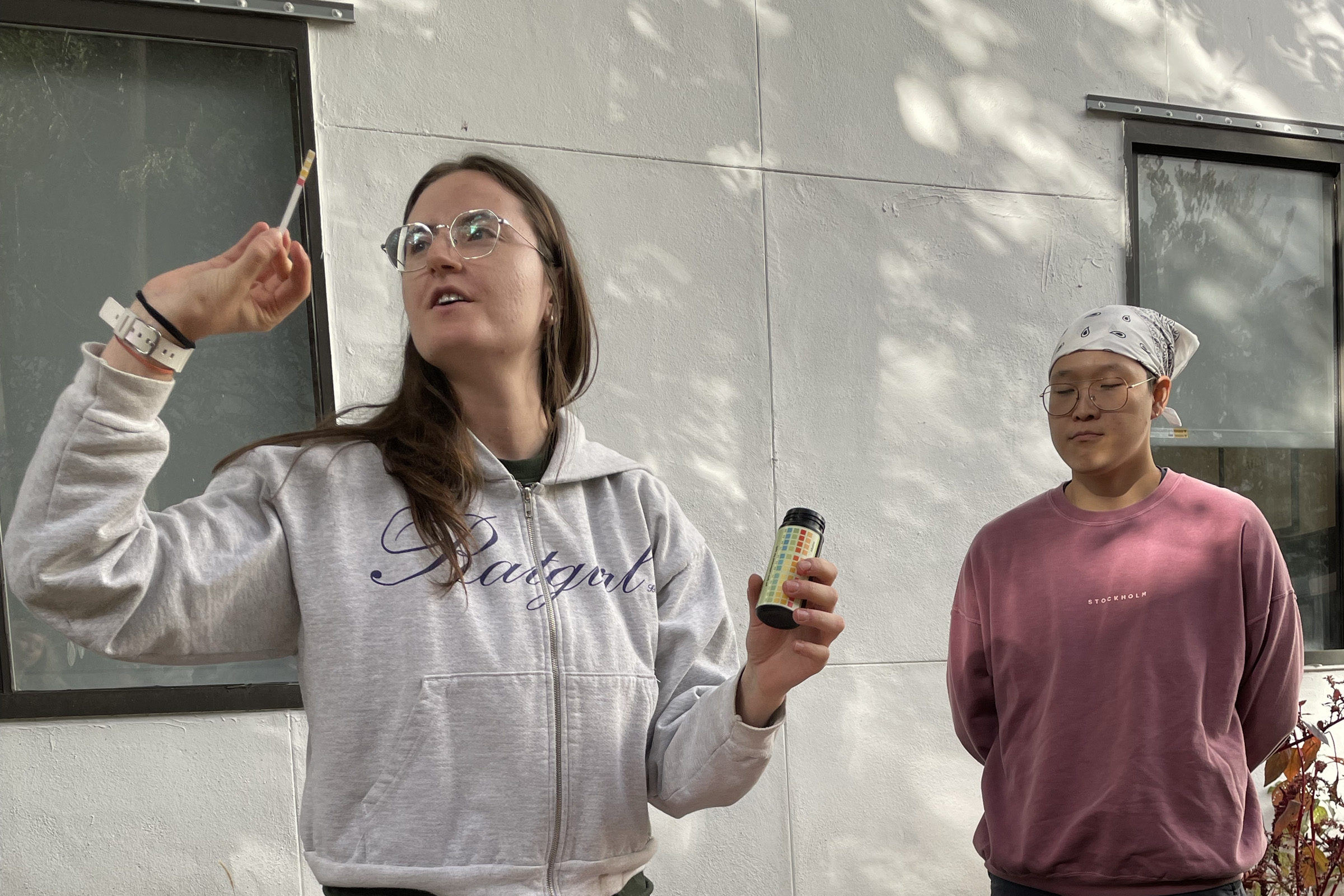 A student testing soil samples collected in a campus garden as a participant in the workshop watches.