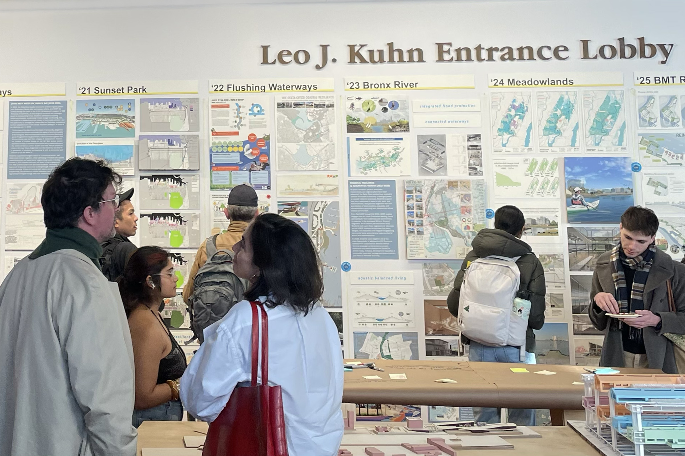 A group of people reading the exhibit materials.