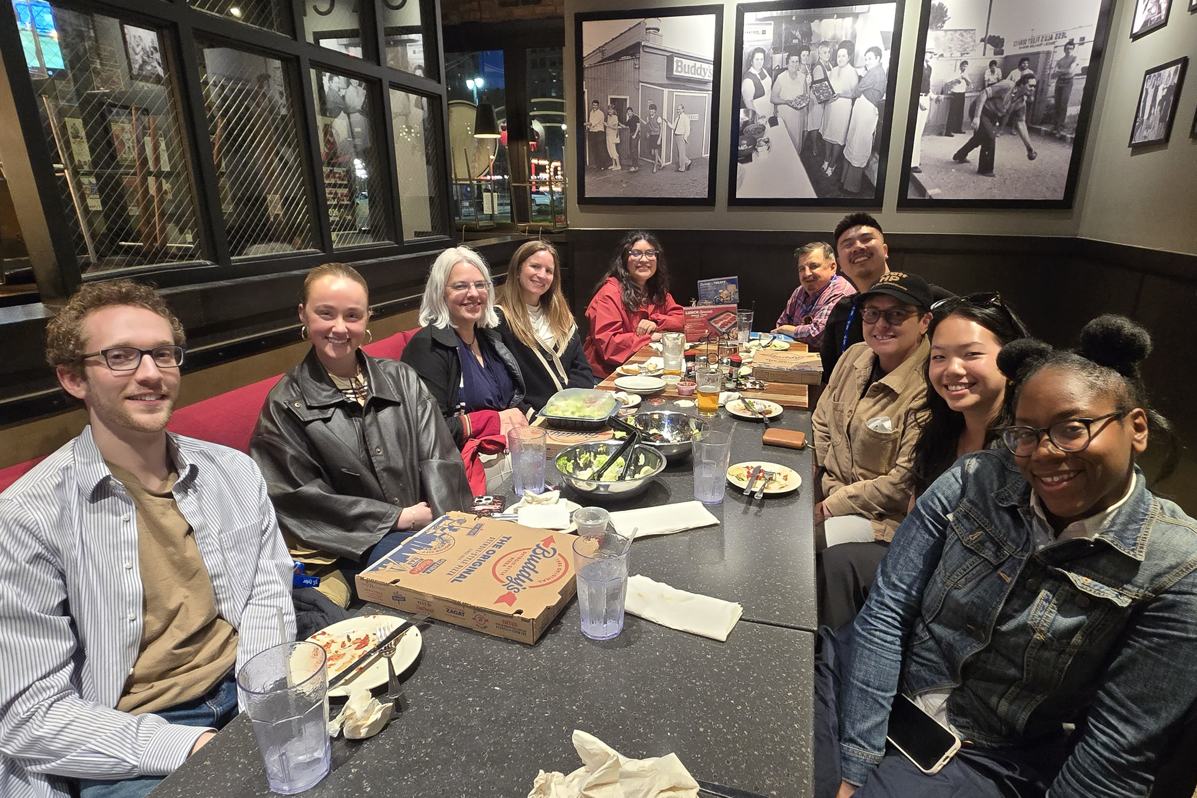 A group of ten individuals sitting at a restaurant table.