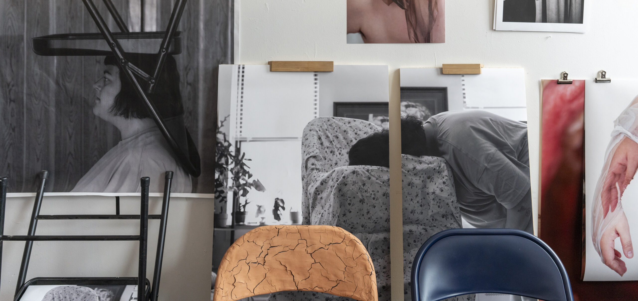 A photography student's cluttered studio, with images of the student and by the student, furniture, and multi media
