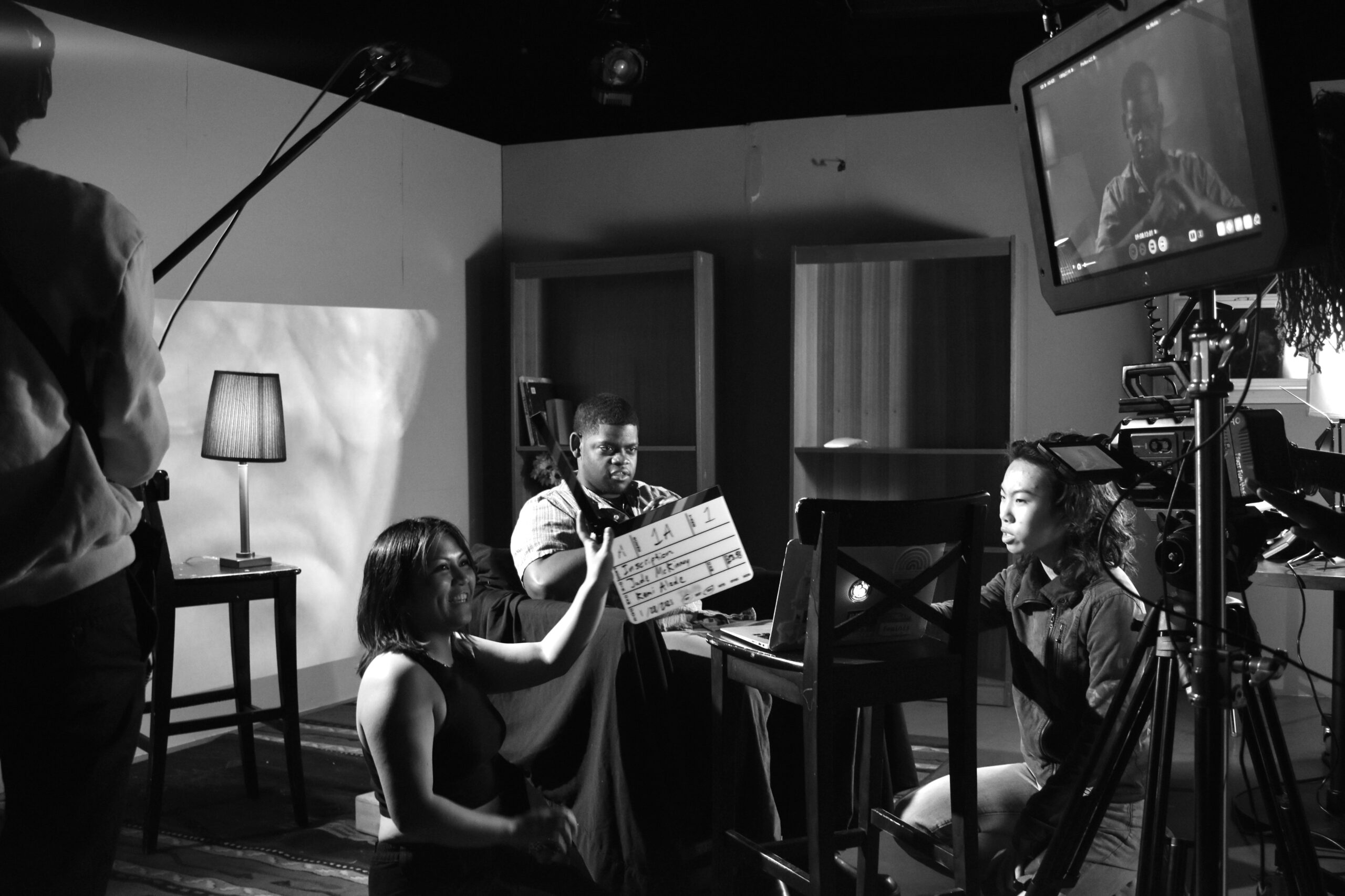 film crew holding timecode board while subject sits in front of camera