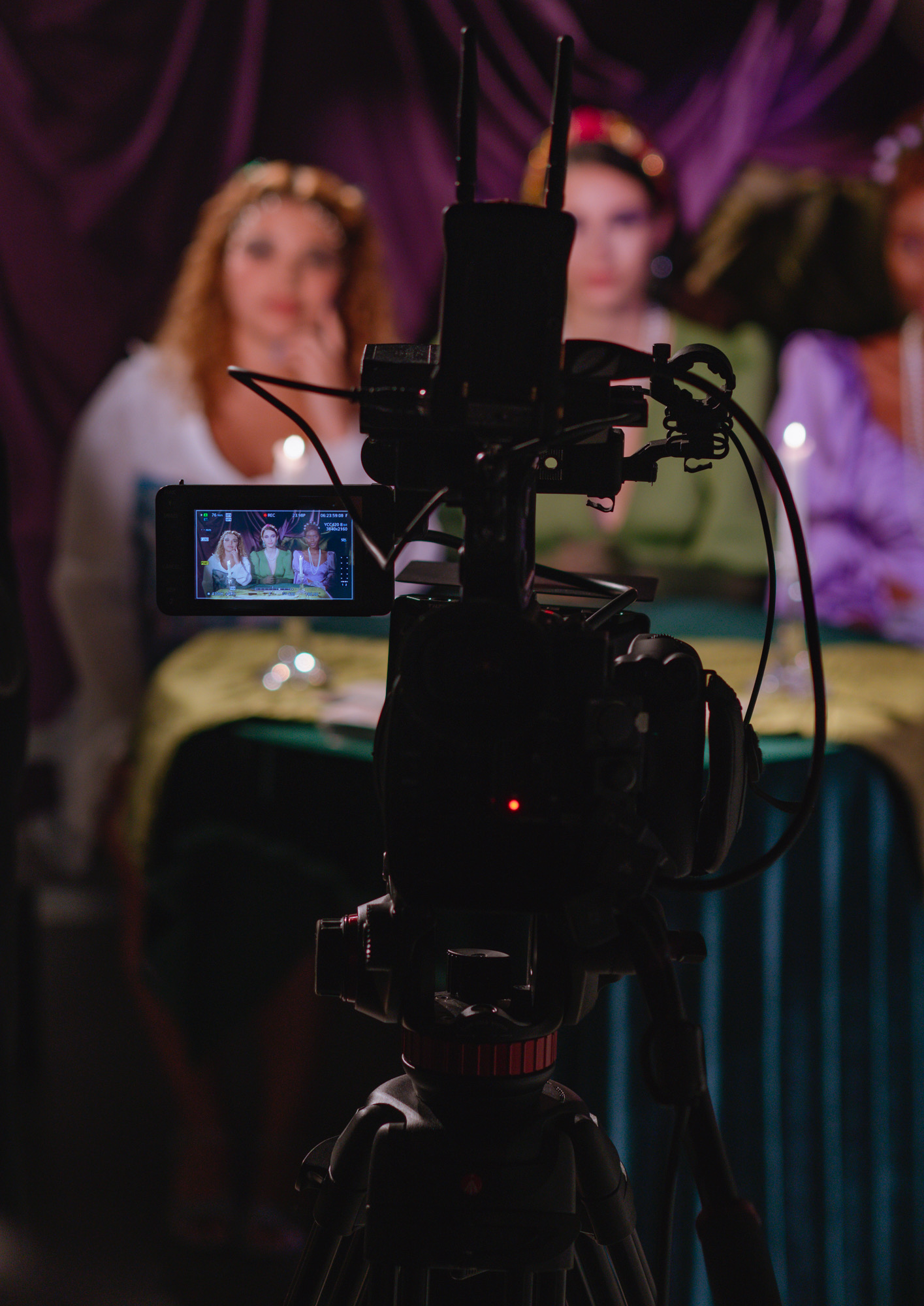 two women in front of a camera, point of view from behind camera