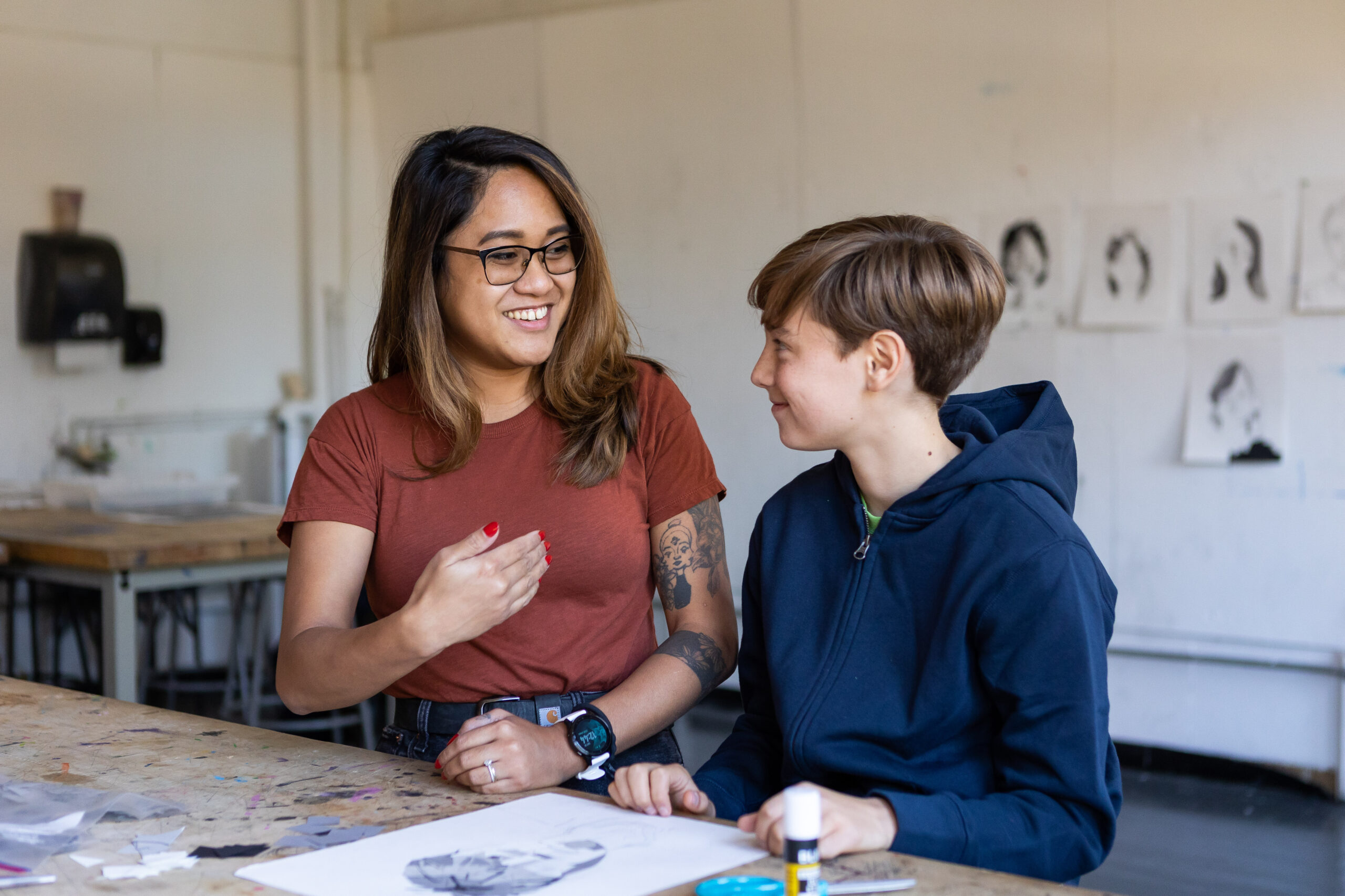 student and student teacher speaking in a classroom