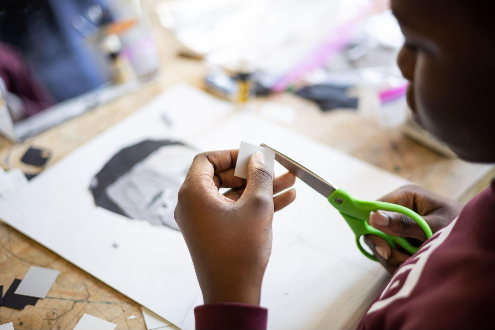 A middle school student working on a self-portrait in collage.