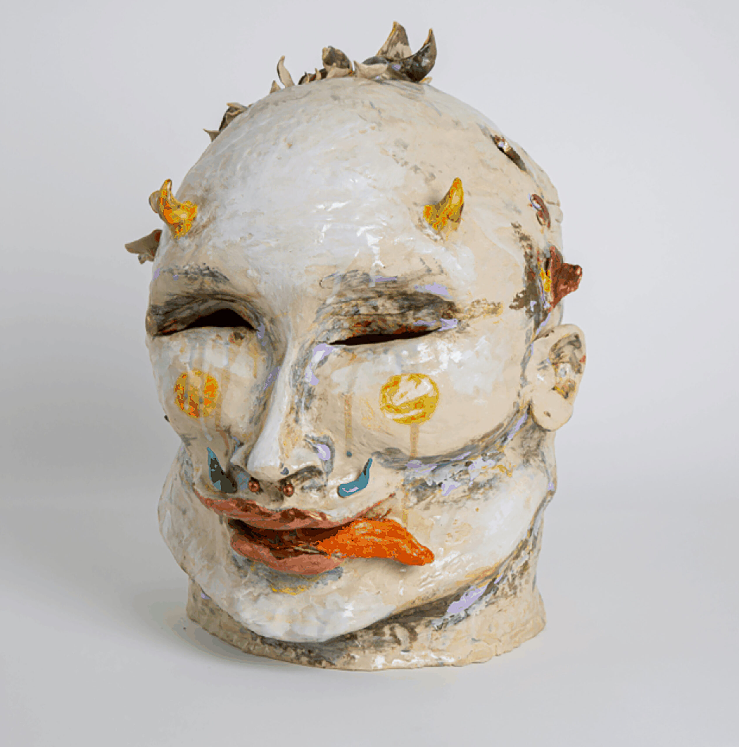 sculpture of a head, appears to be ceramic, with white paint as a base and bright colors to denote lines