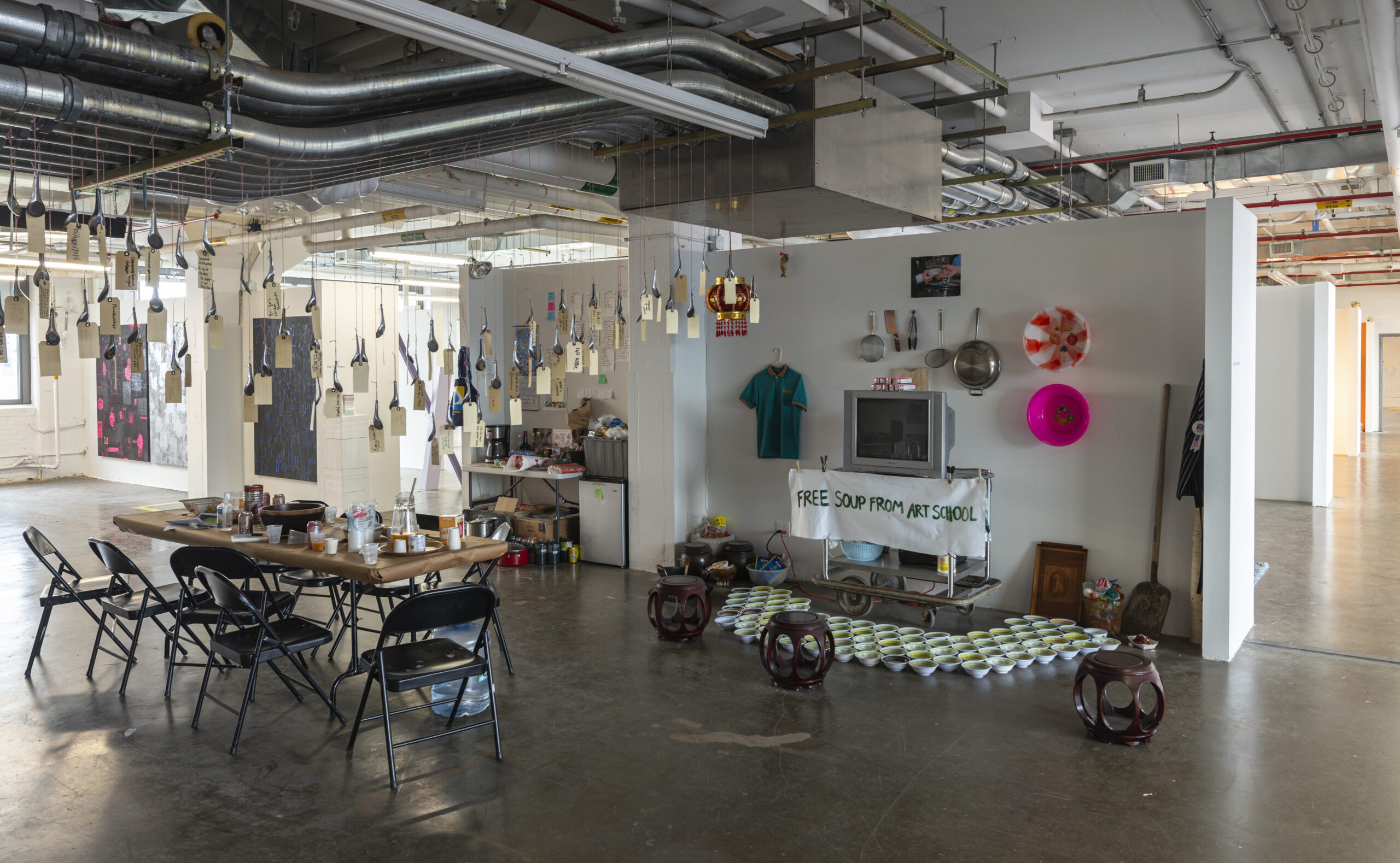 art installation, in large room, with objects hanging from ceiling