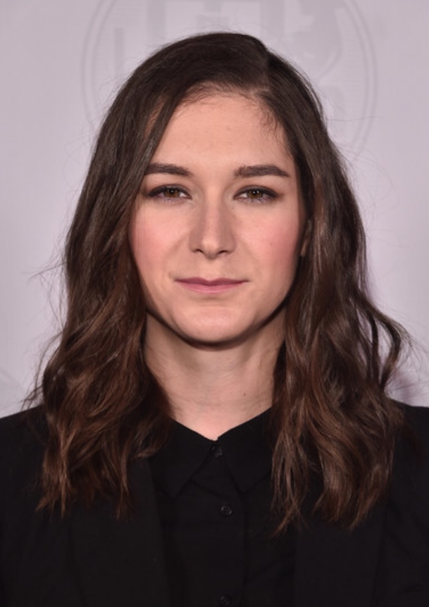 A headshot of a woman with long brown hair.