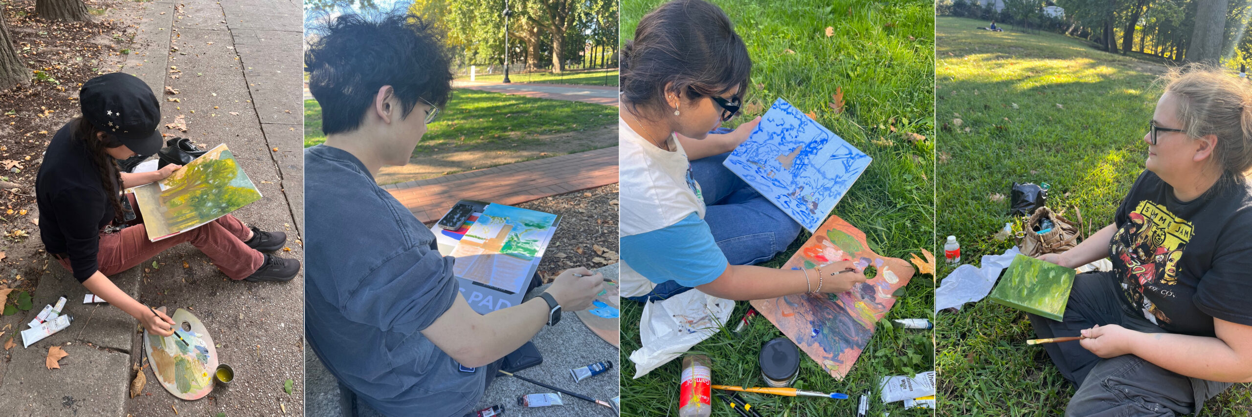 Four artists are creating paintings in a park. The first artist, on the left, sits on a sidewalk, holding a paintbrush and palette, focusing on a landscape. The second artist, in the middle, works on a larger canvas, while the third artist, on the right, uses a paint palette and sits on grass, wearing sunglasses. The fourth artist, also on grass, is finishing a green landscape painting. The surroundings include trees and fallen leaves, indicating autumn.