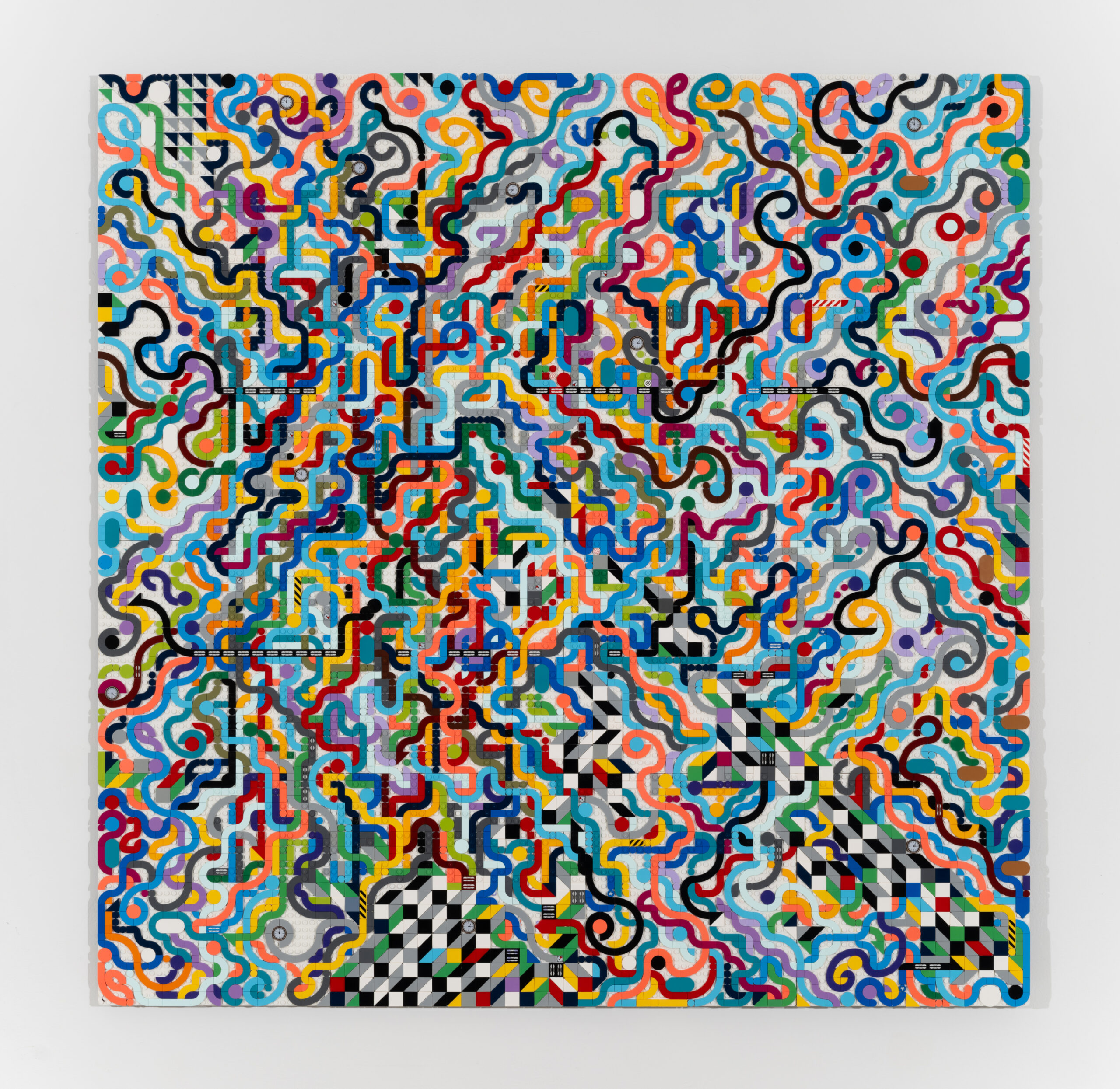 A square artwork made of multicolored Lego bricks arranged in an abstract pattern.