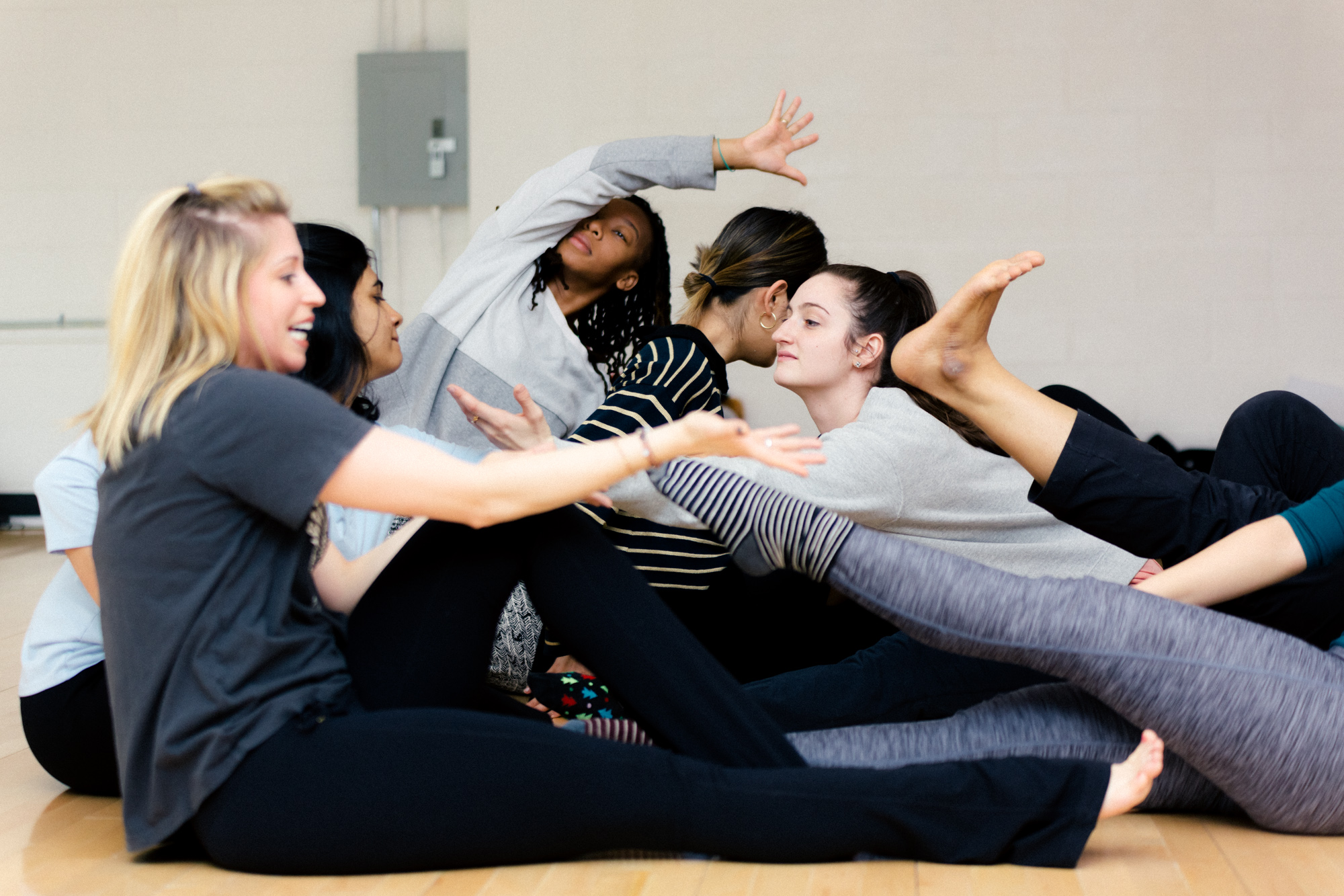 A group of people laying on the floor in different positions their bodies are enter twined with each other.
