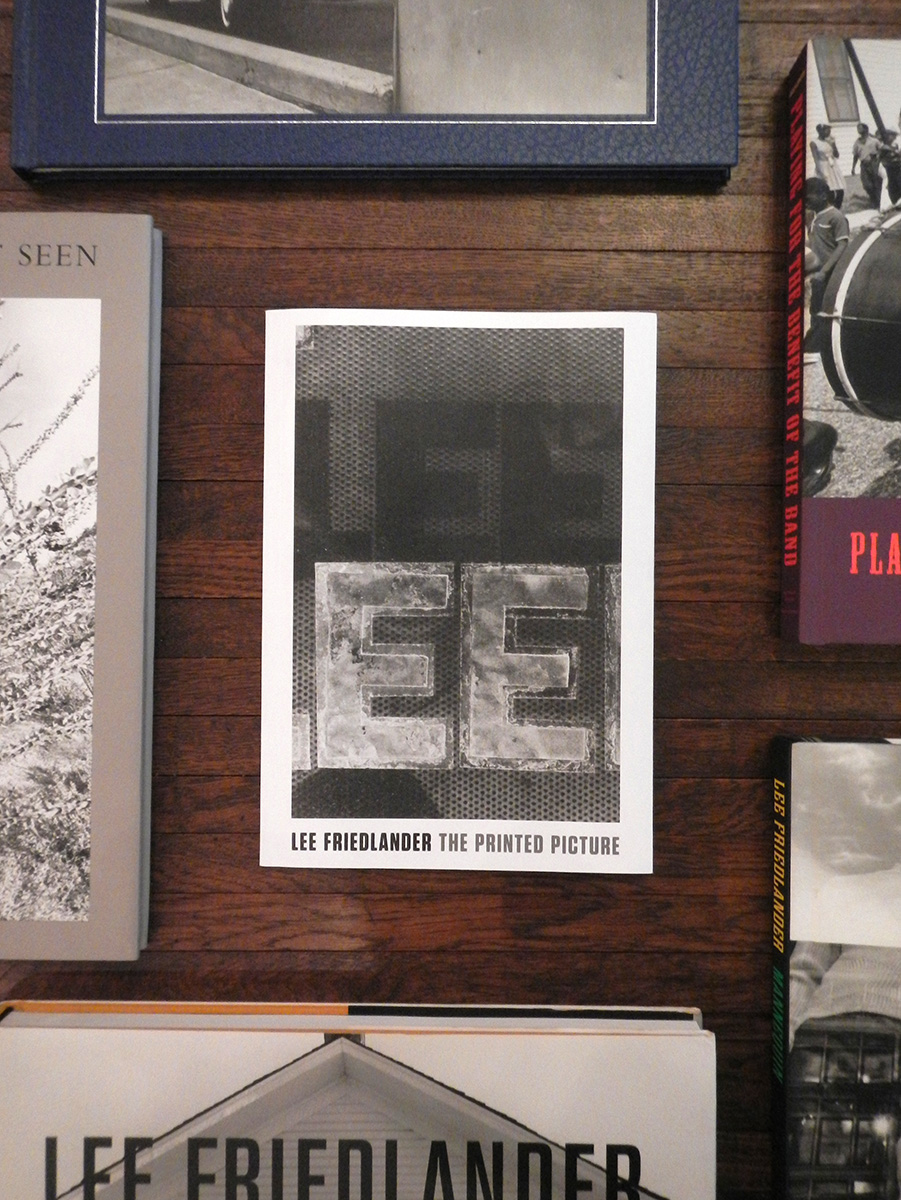 Photo of a wooden desk with a copy of Lee Friedlander's The Printed Picture at the center.