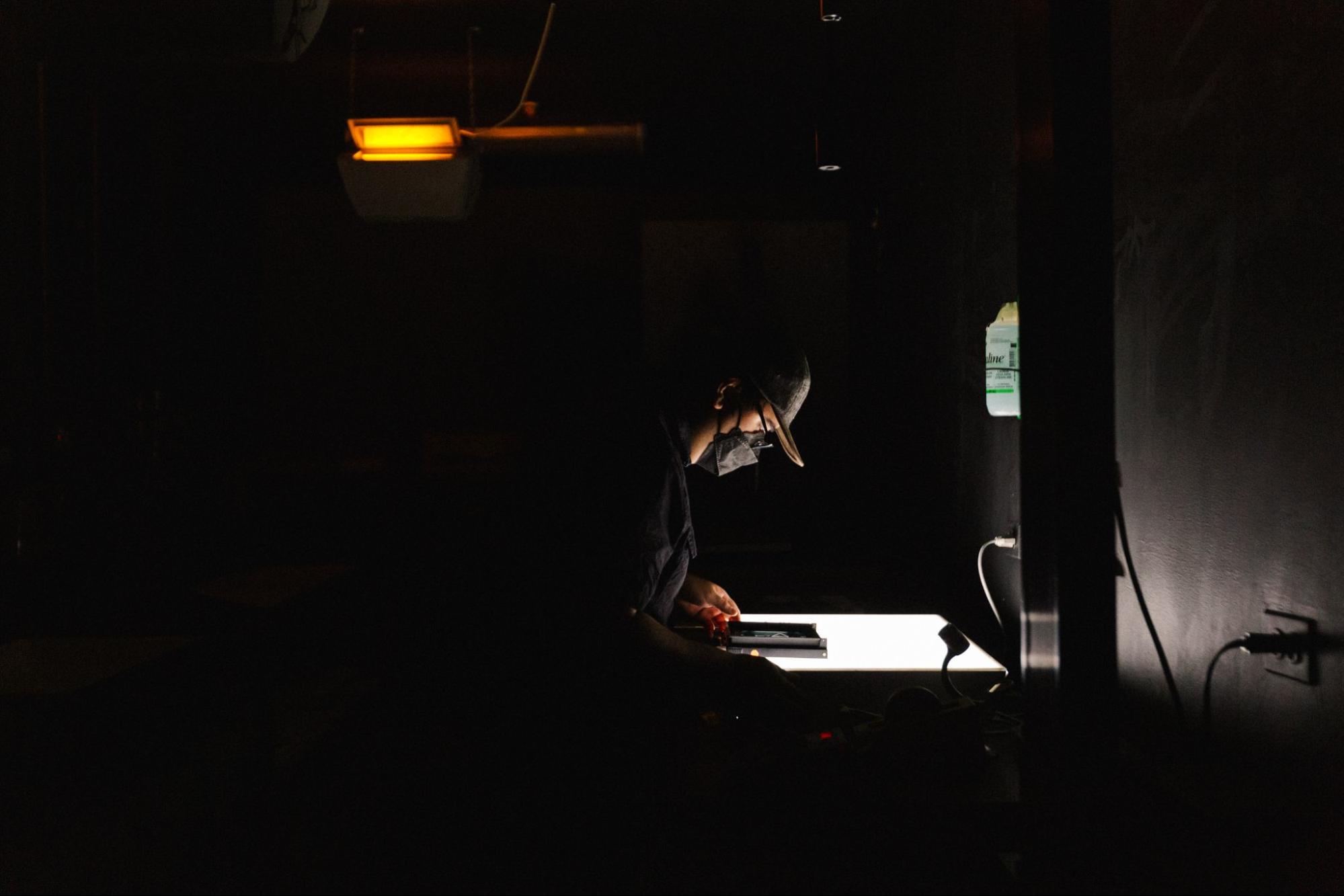 student, masked, using lightpad in studio