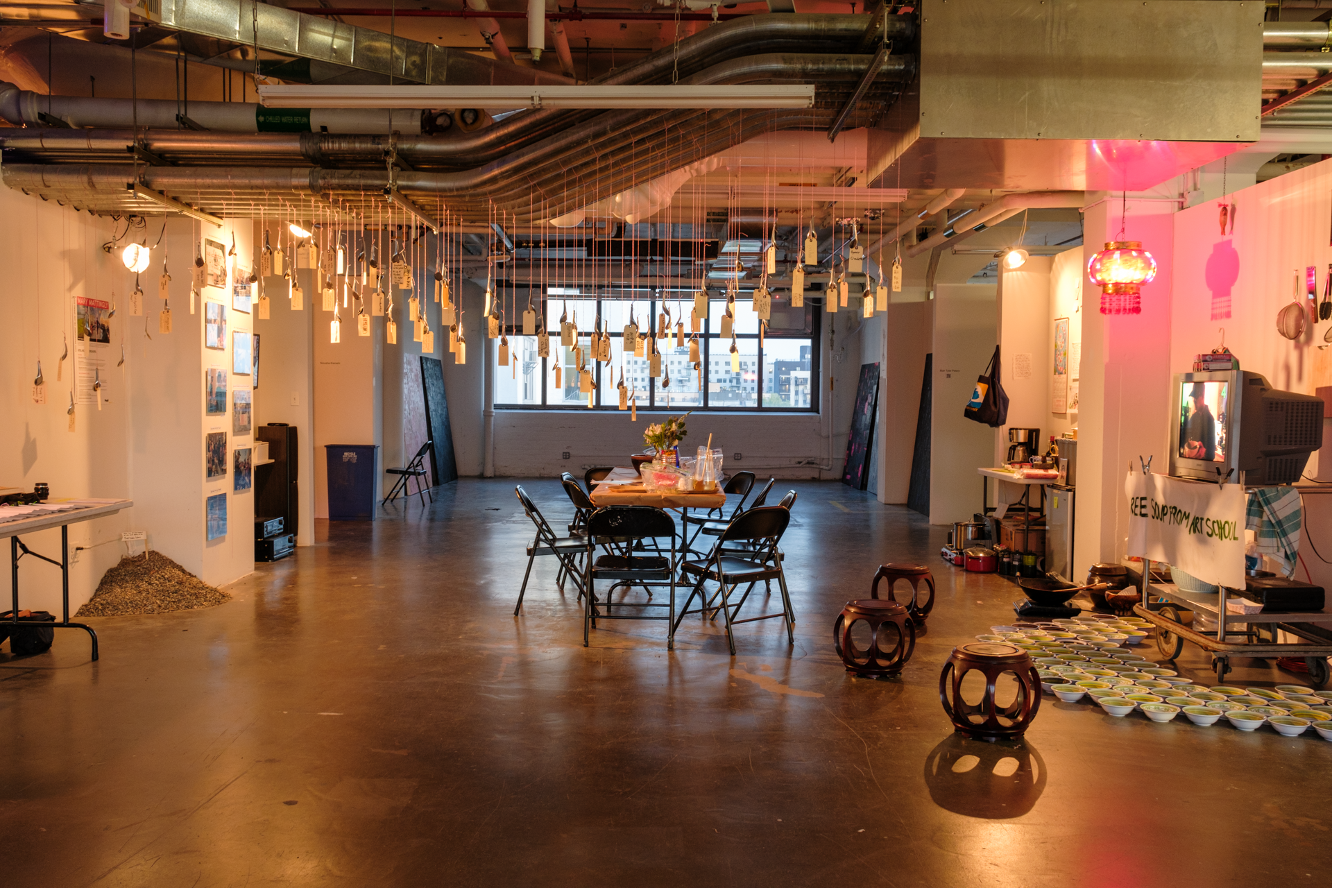 art installation, in large room, with objects hanging from ceiling