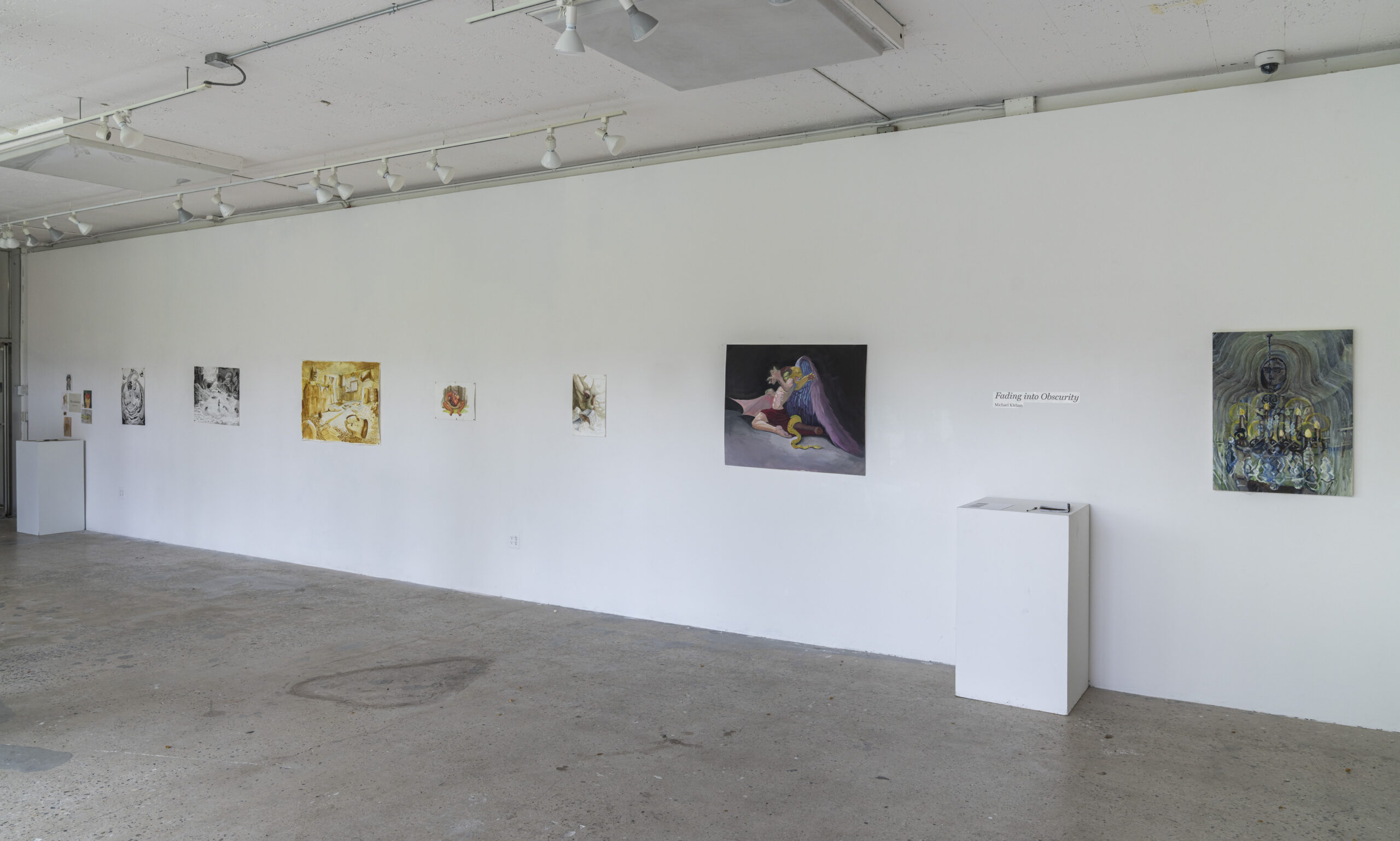 A gallery exhibition featuring a mix of surreal and urban-inspired paintings. On the left, a dramatic painting depicts a figure in a dark setting, while the right side showcases works exploring themes of city life, neon lights, and subway environments. The white walls and minimalist layout emphasize the vibrancy and detail of each piece.