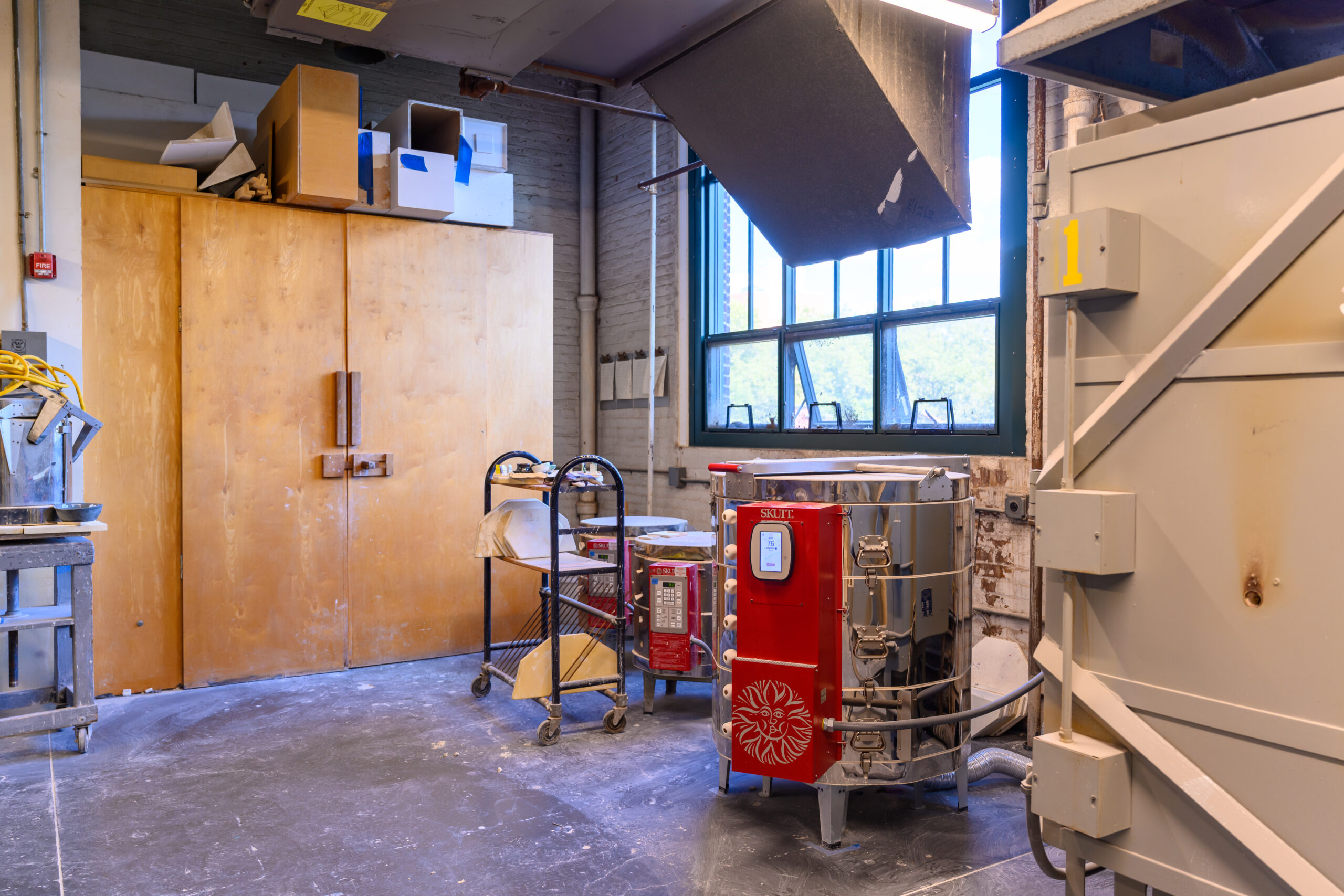Photo from Fine Arts ceramics shop featuring large wood storage cabinets and a kiln