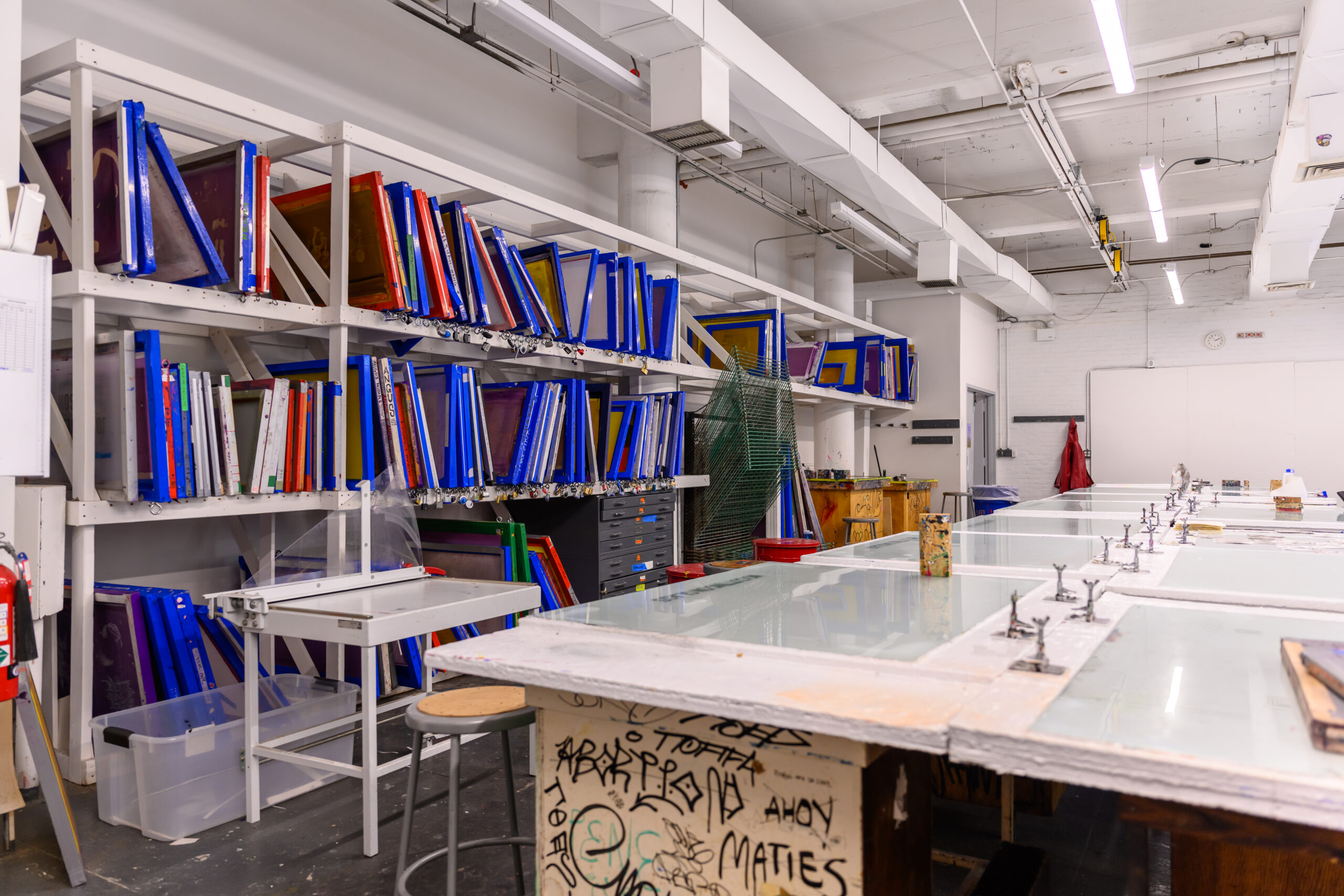 Fine Arts screenprinting shop, with a rack of dozens of screens against the left wall.