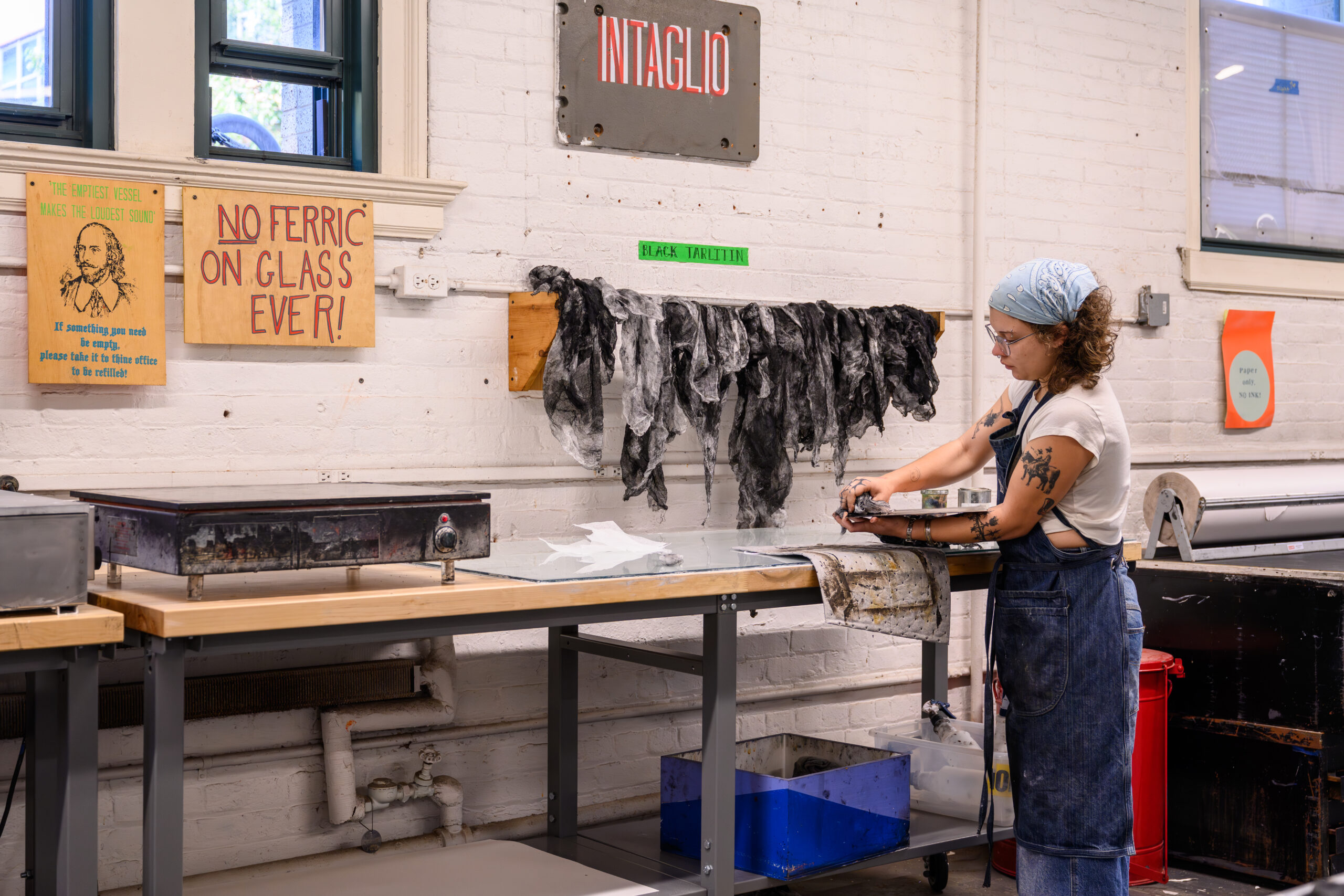 A student scrubbing a plate in the Fine Arts intaglio studio