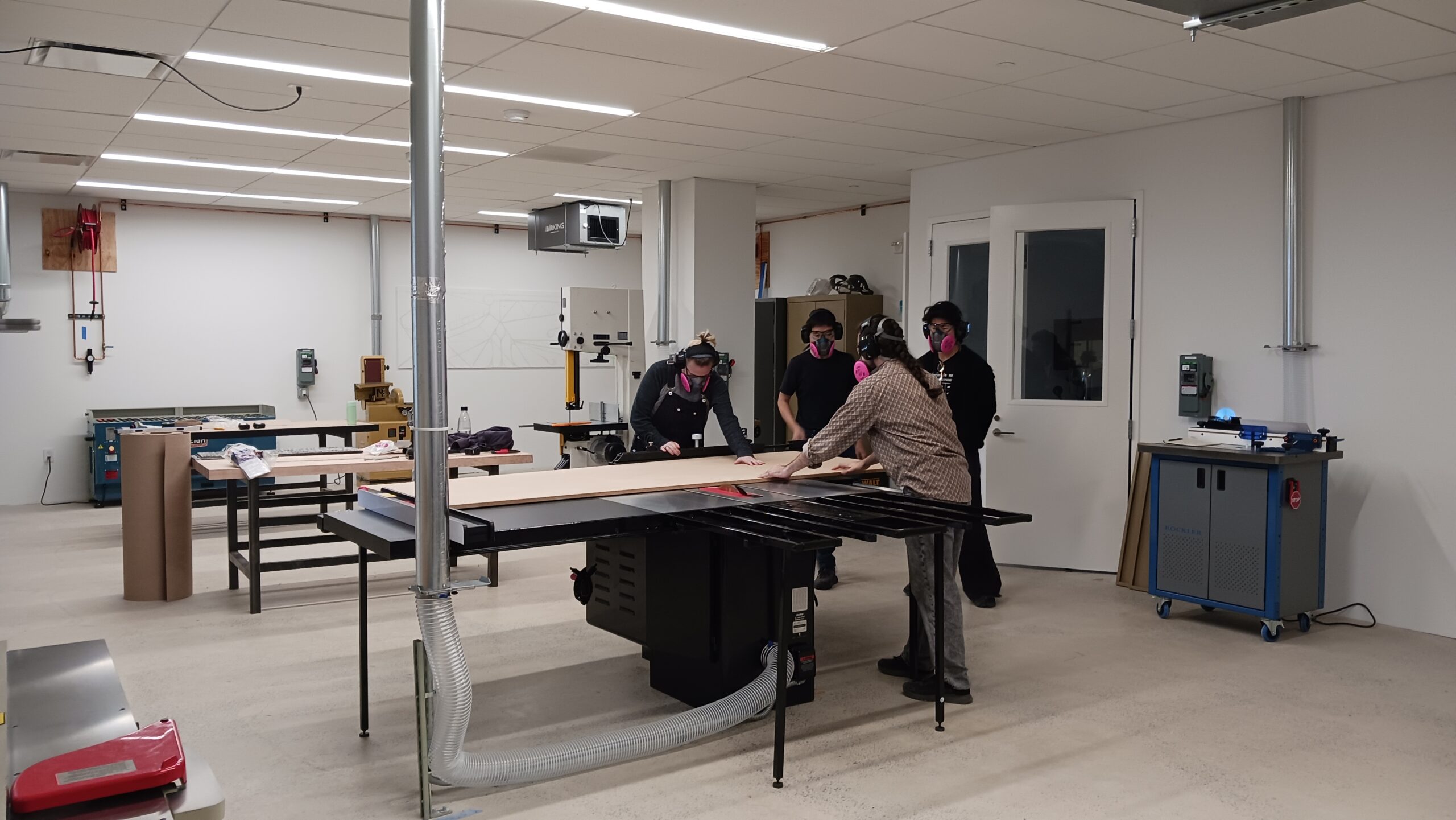 A group of people working in the graduate Fine Arts wood shop at Dock 72