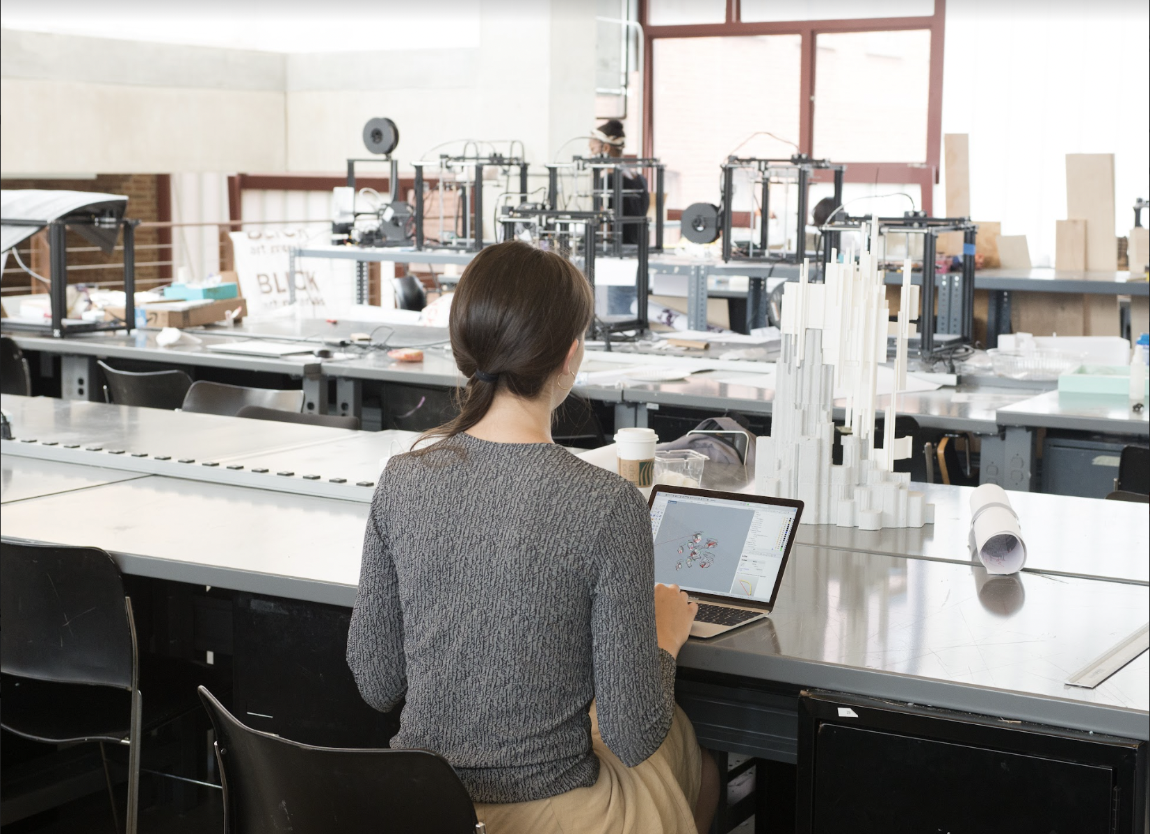 female student in lab, taking notation down on tablet