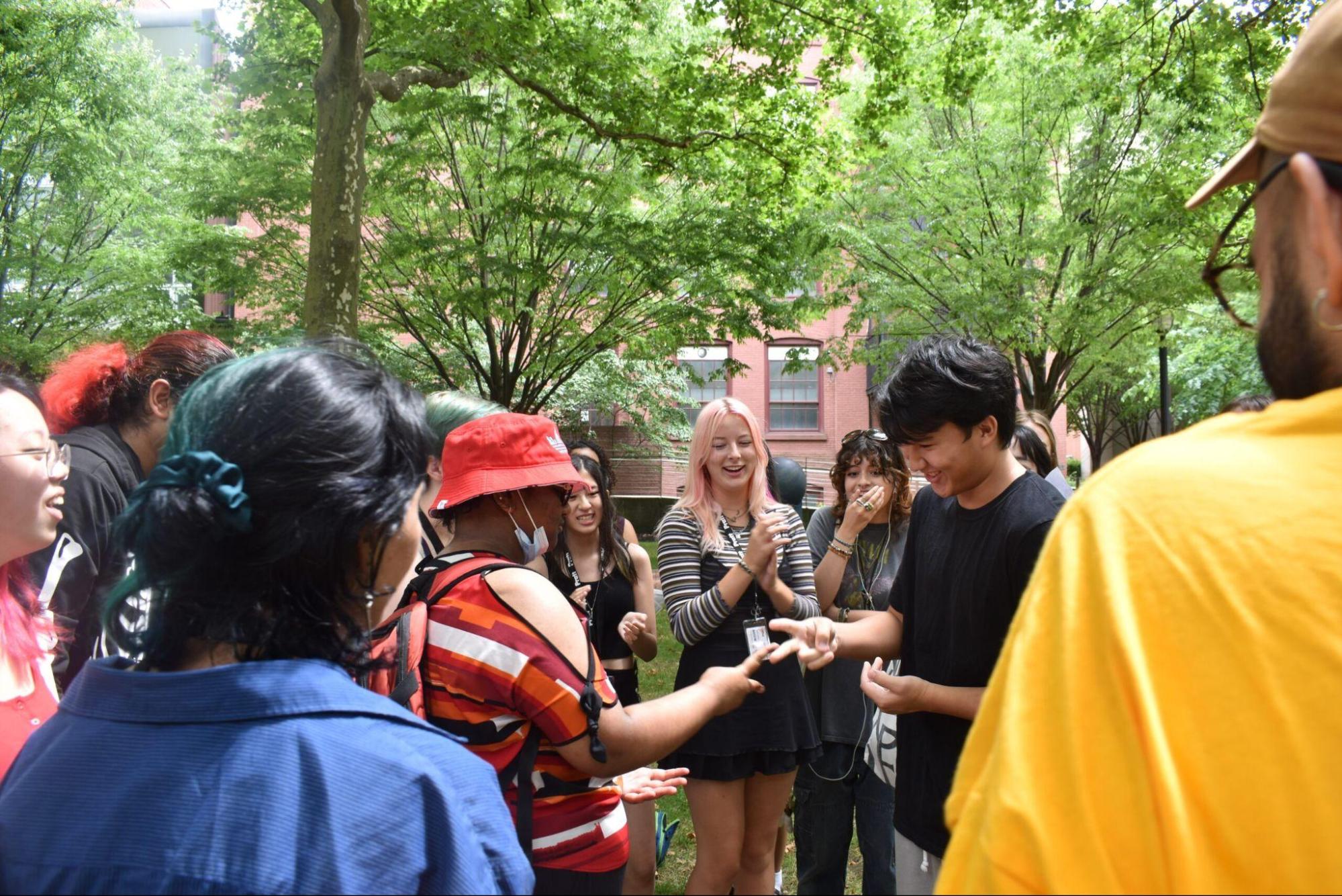 students on campus, playing rock paper scissors