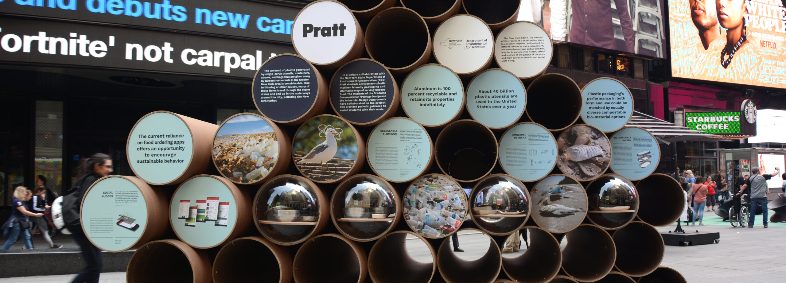 A stack of metal tubes with circular cutouts with printed information at the mouths of many of the tubes.