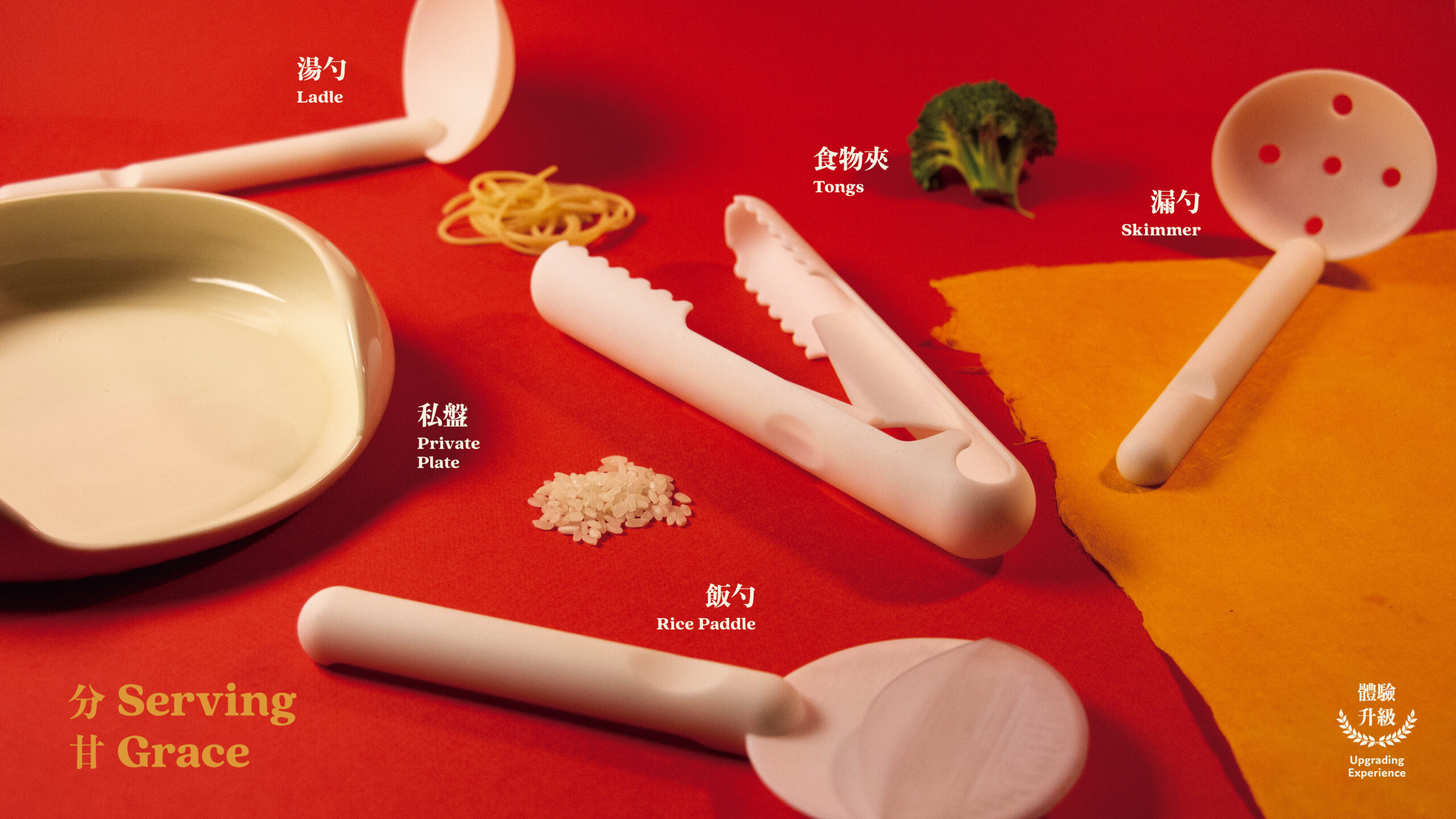 A cooking utensil set rest atop a red-colored surface. There are small amounts of food sitting next to the every utensil that correspond to their use in the kitchen setting.