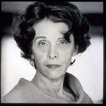 a black and white photograph of a white woman of middle age making eye contact with the camera, a proud expression on her face
