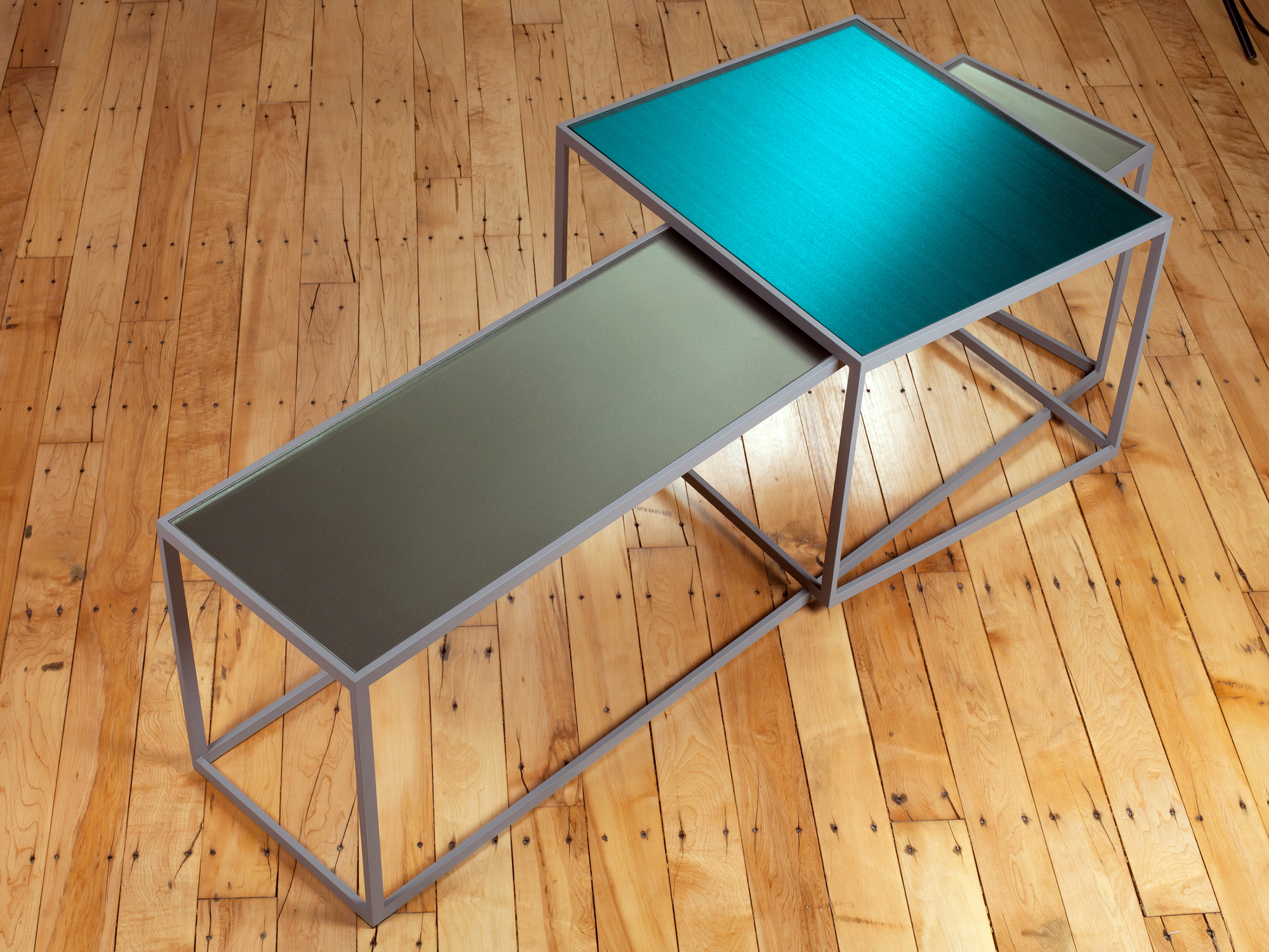 two rectangular volumes on a wood floor. they are hollow, but one has a blue top and one has a gray top.