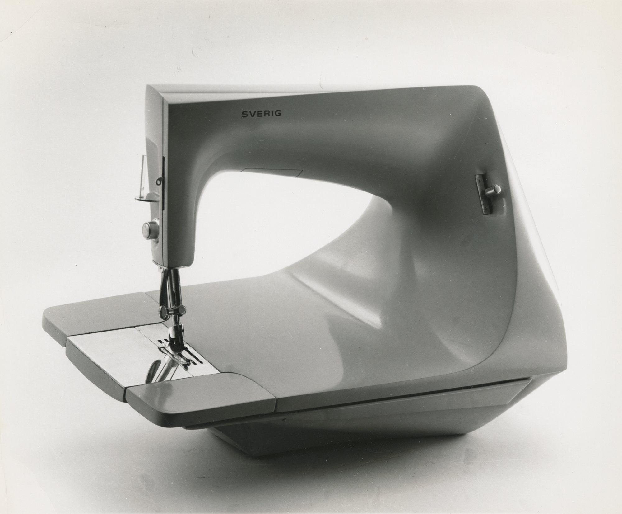 a black and white photograph of a sewing machine with a cantilevered base