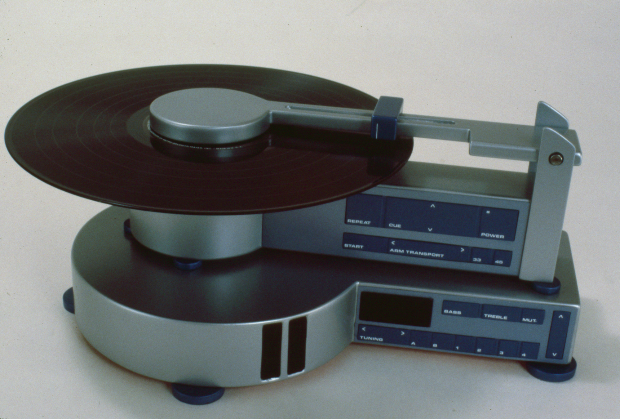 a gray metal experimental record player where the record sits over an empty space