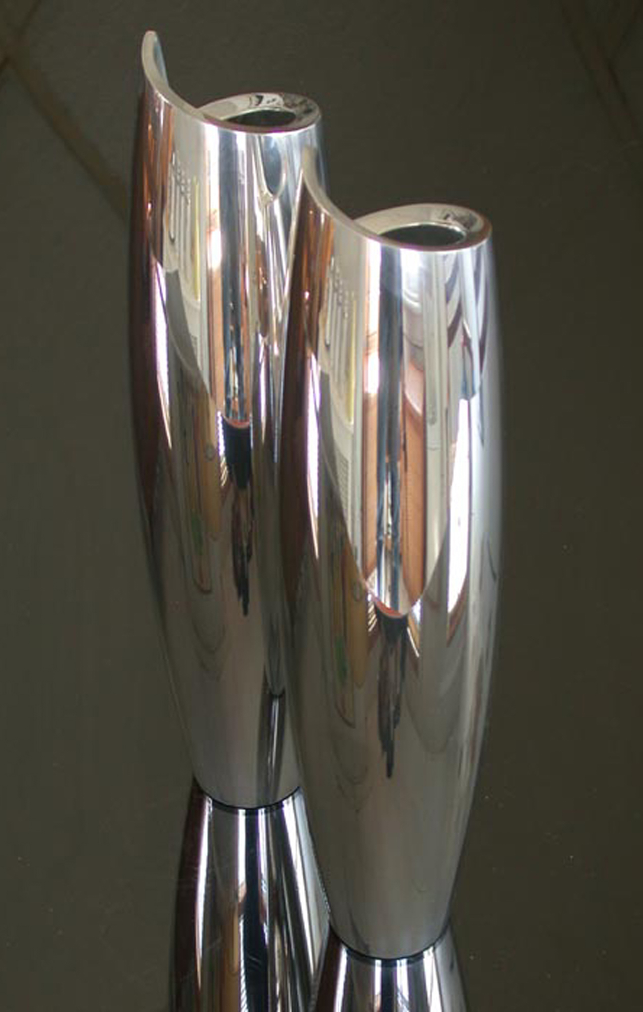 two narrow vases made of curled chrome planes