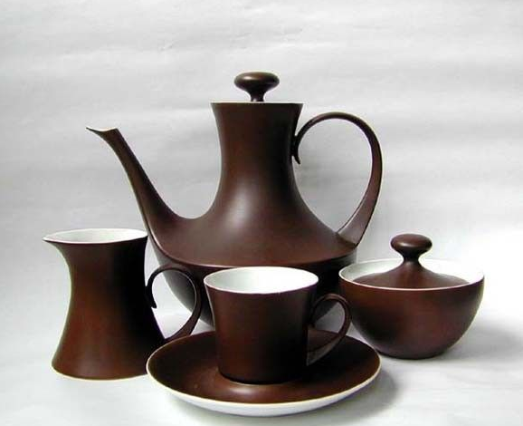 a brown teapot, cup, saucer, and pitcher