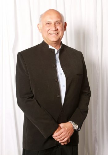 a bald man smiling in a blazer