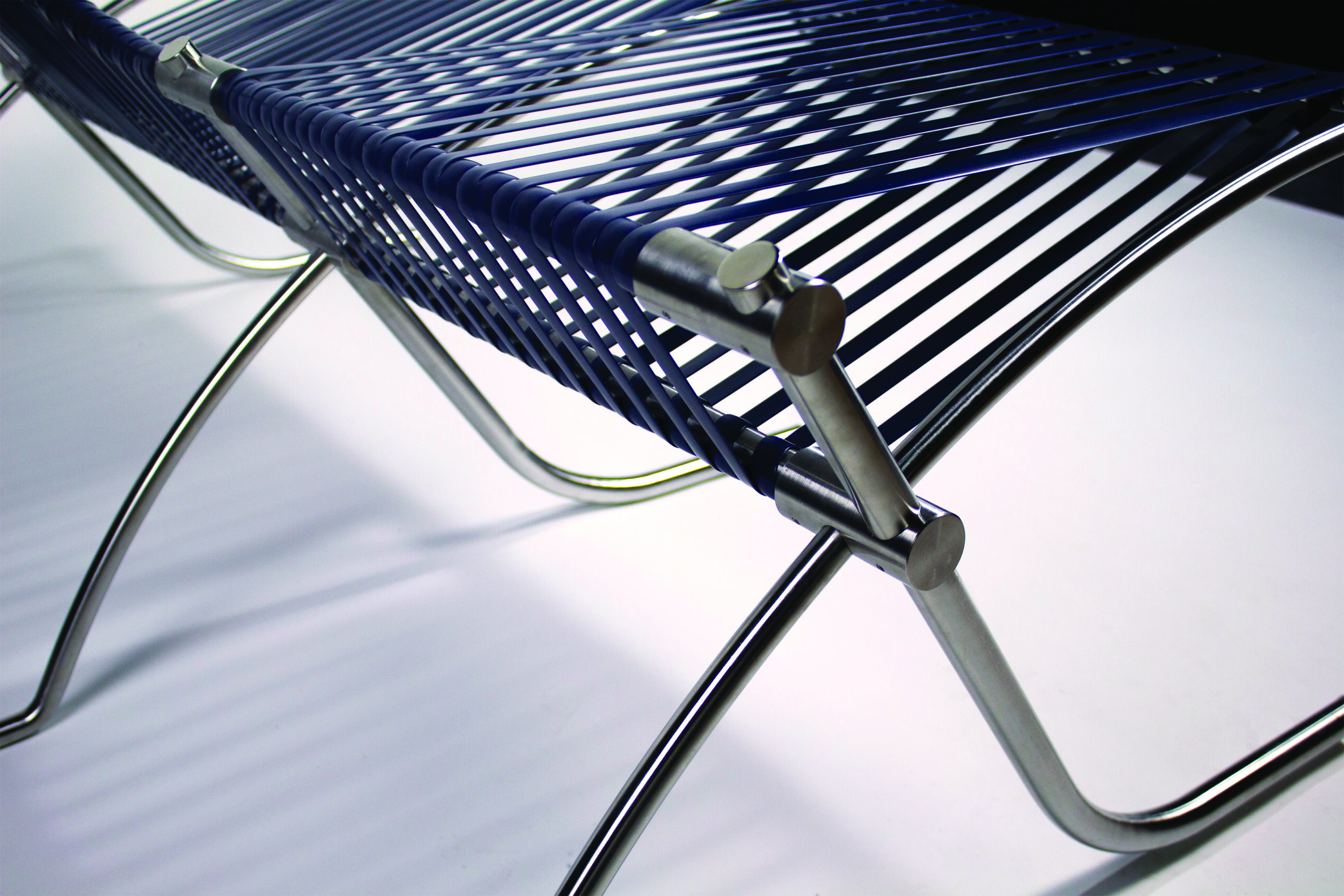 a detail photograph of a metal frame of a bench with slats running across it.