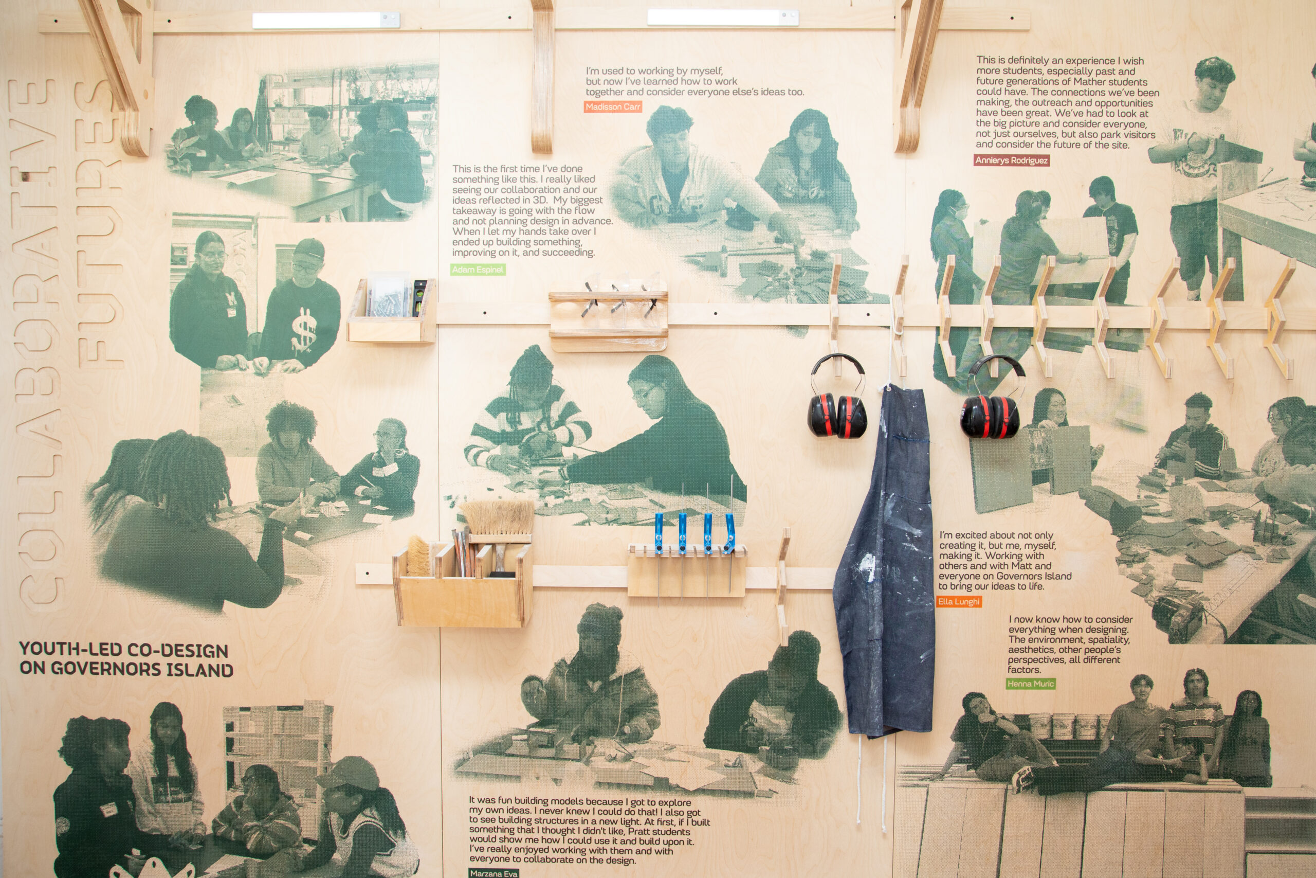 A wooden wall features text quotes from Annjerys Rodriguez, Ella Lunghi, and Henna Muric, reflecting on engaging experiences related to design and collaboration. Below the quotes, images of students working on projects are visible. There are also wooden hooks holding a dark apron and headphones, adding a tactile element to the display.