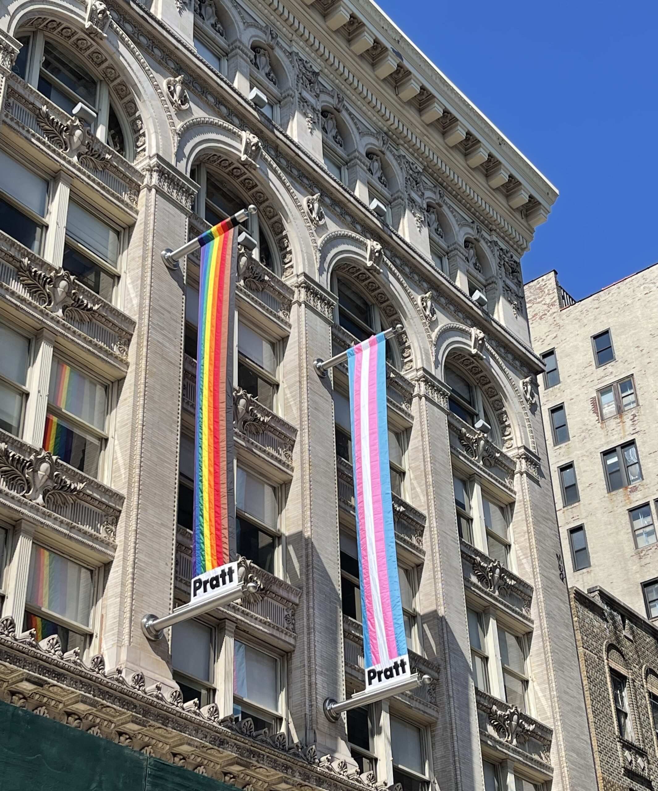 Image of the Pratt Manhattan Center with pride flags hung from it.