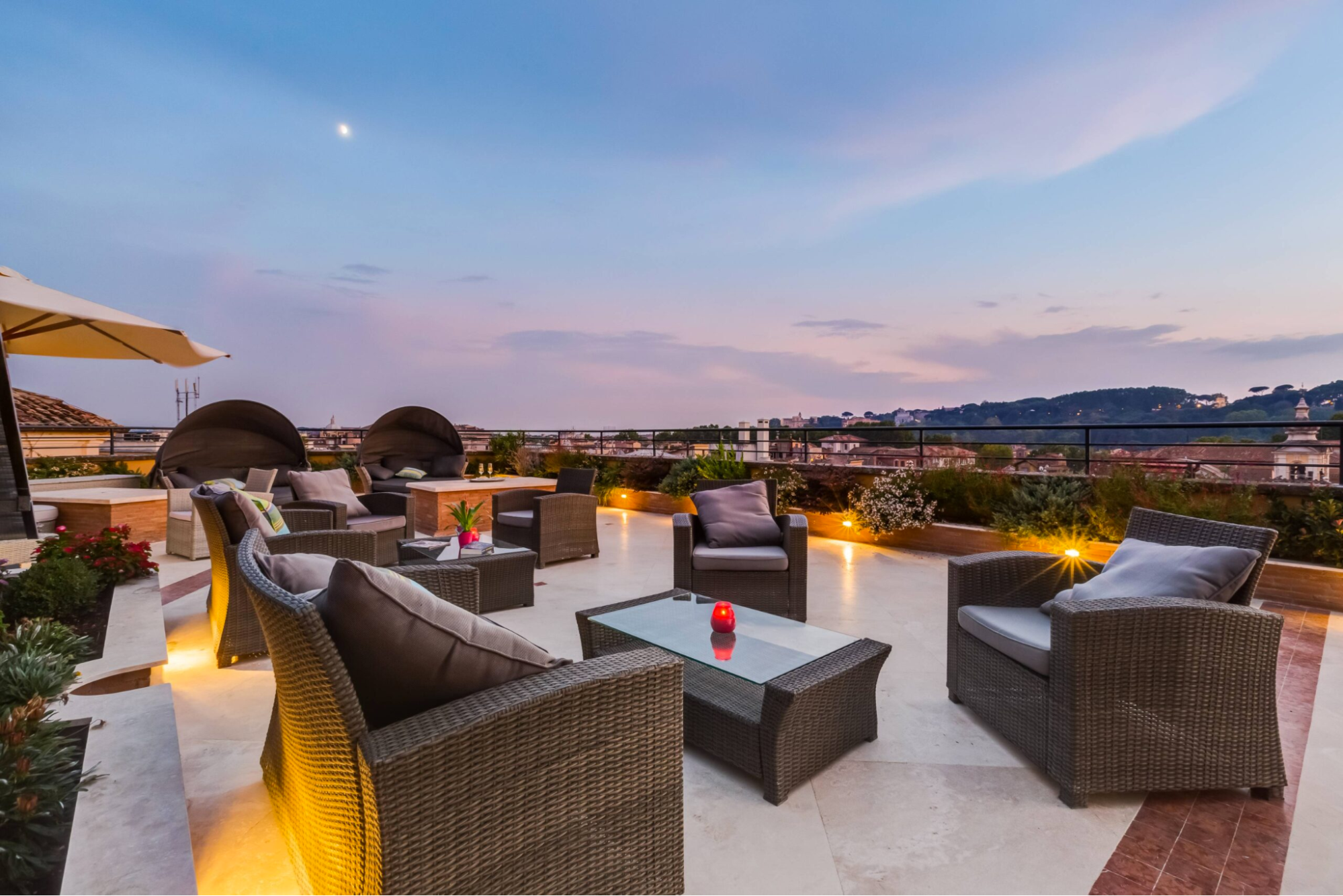 rooftop plaza with seats and lounging area overlooking a mountain with sunset