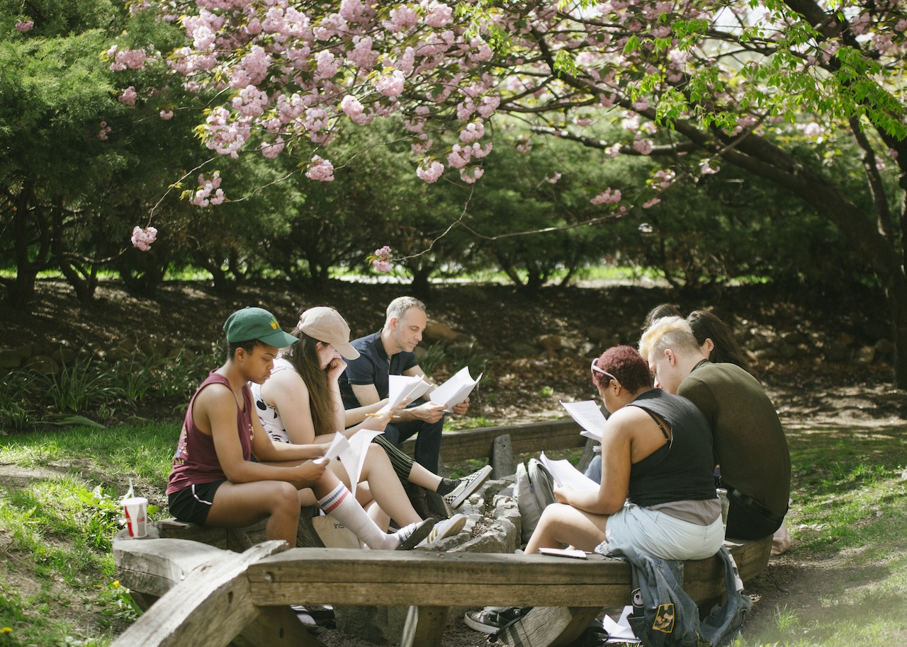 students gathered around a picnic table, on campus